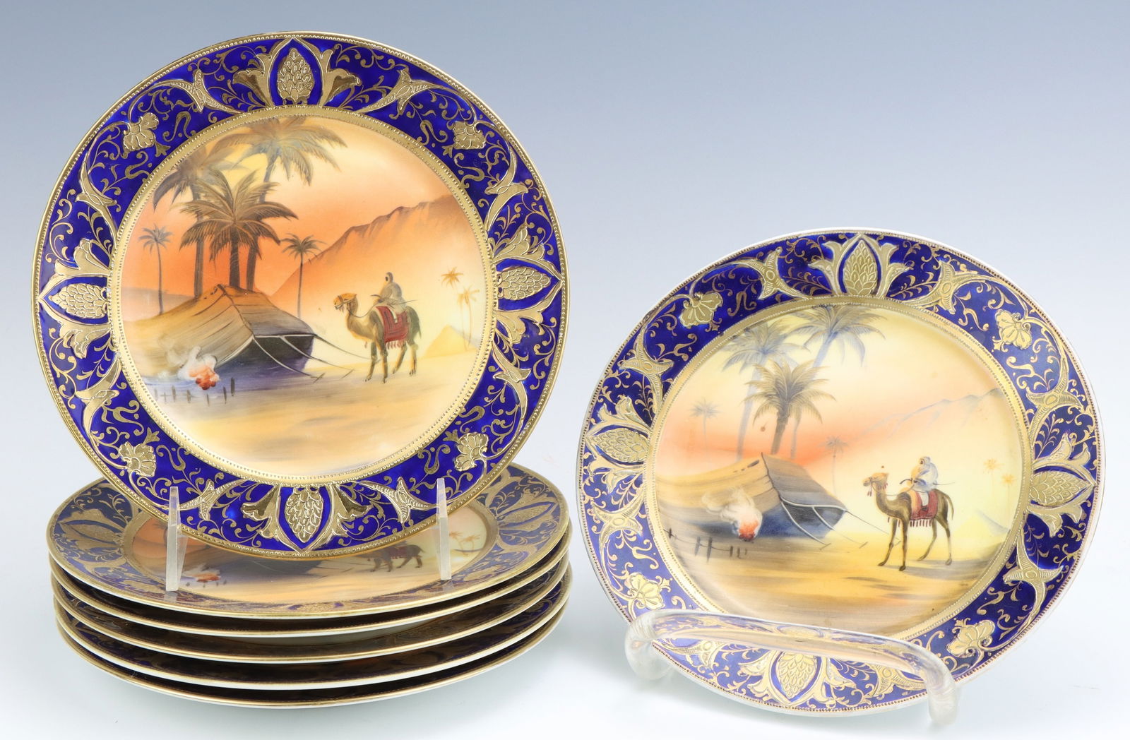 Noritake Porcelain Plates: Noritake porcelain plates (7), Egyptian desert, cobalt, gilt decoration, marked, 0.75"h x 7.75"dia.