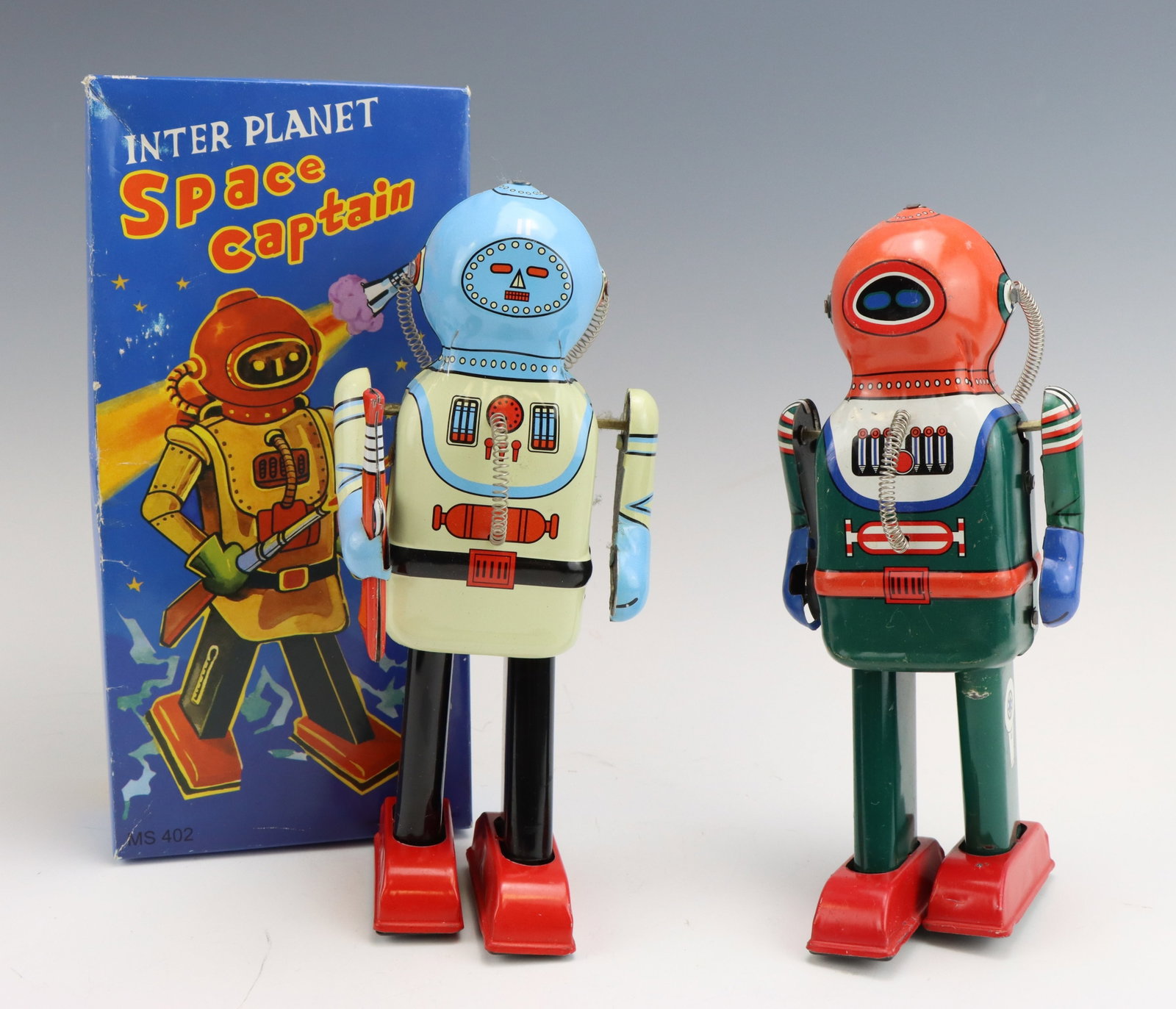 Inter Planet Space Captains: Tin litho Inter Planet Space Captain toy robots. One has original box and both are wind-up functional. Box measures 3.25”h x 4.5”w x 9.5”d