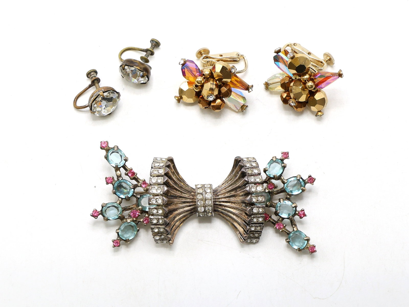 Sterling Silver Rhinestone Brooch and Vendome Earrings: Sterling silver brooch with aquamarine and pink rhinestones and clear accents. Includes one pair of Vendome gold-tone floral earrings with amber and crystal elements and one pair of unmarked clear rhi