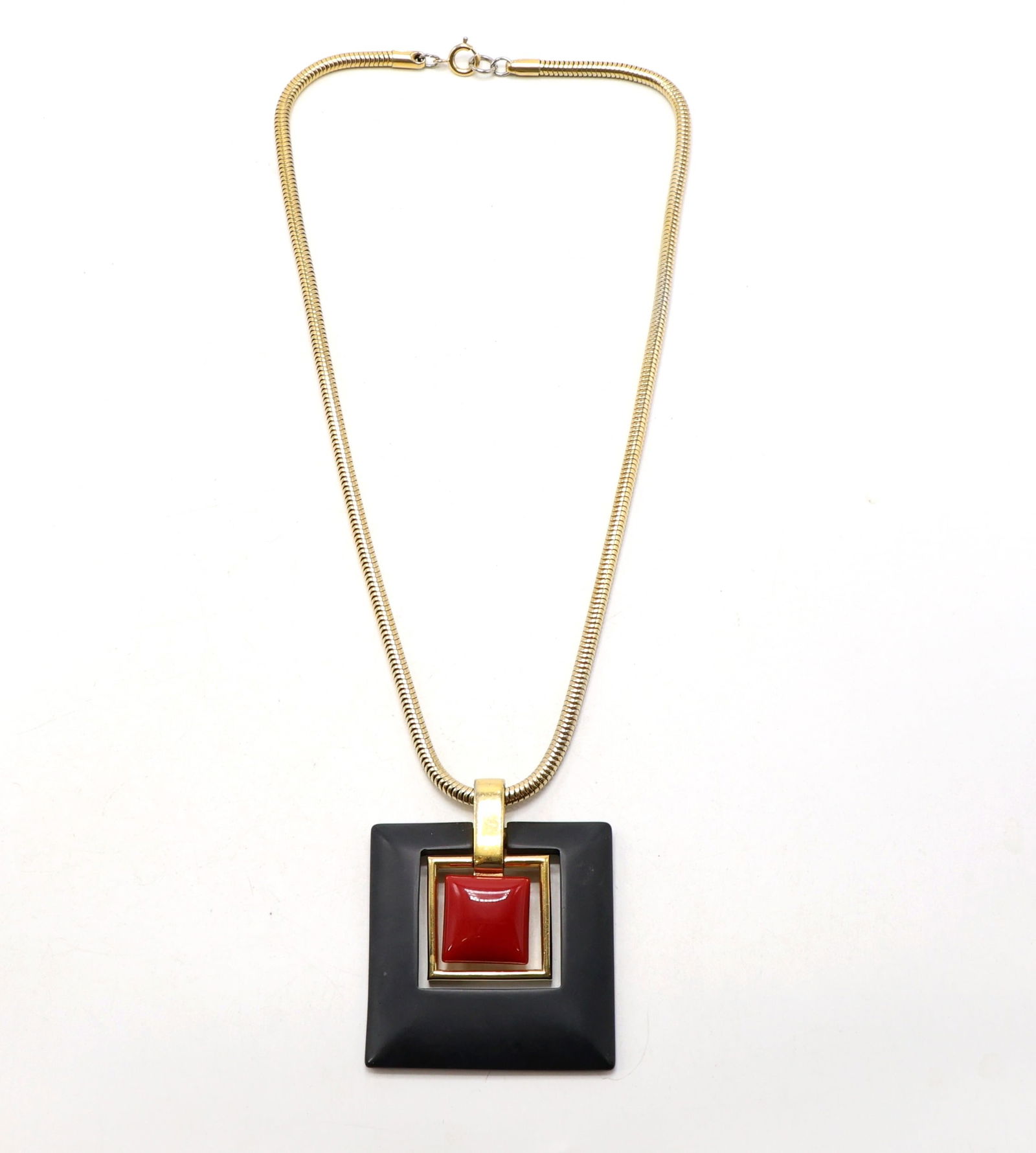 Trifari Pendant Necklace: Trifari pendant necklace featuring a geometric layered design. The pendant includes a black square outer piece, gold-tone middle frame, and red center accent. The necklace is a gold-tone snake chain w