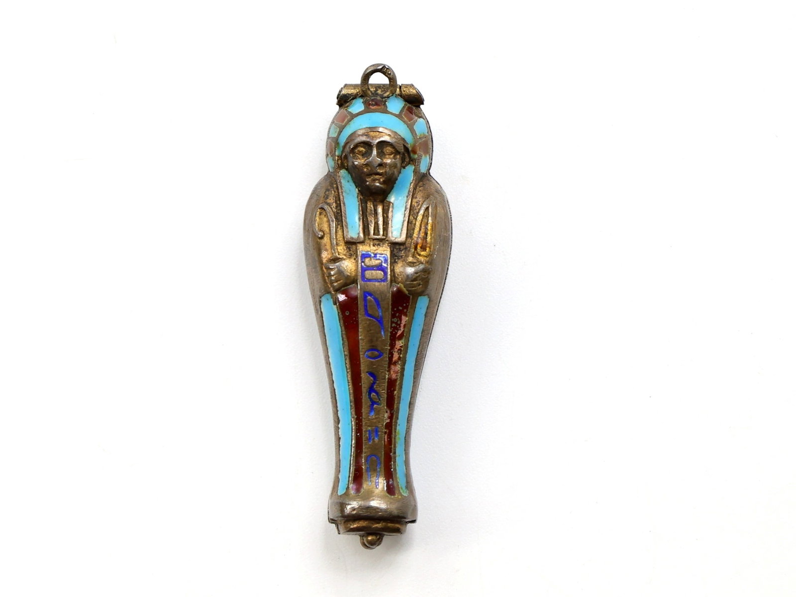Sterling Silver Egyptian Revival Pendant: Sterling silver Egyptian Revival gilt and enamel pendant designed as a sarcophagus. Features turquoise and red enamel decoration on the exterior. Opens to reveal a miniature gilt mummiform figure and 