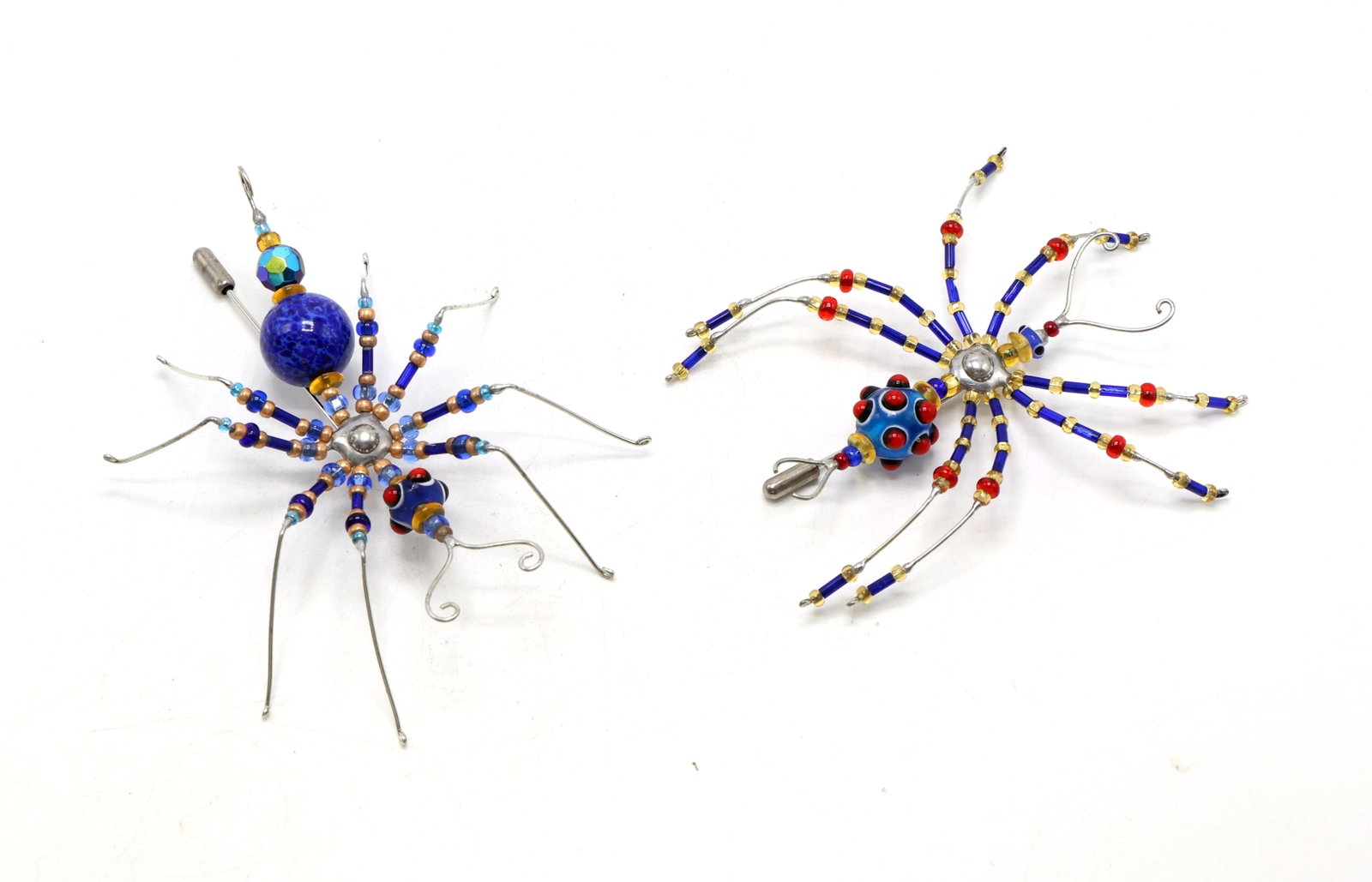 Bugs of Baltimore Insect Sculpture Pins: Glass and wire insect figurines crafted with glass accents in red, blue, and gold tones, constructed with wire frames and ornamented with large central beads in vibrant colors. Designed with intricate