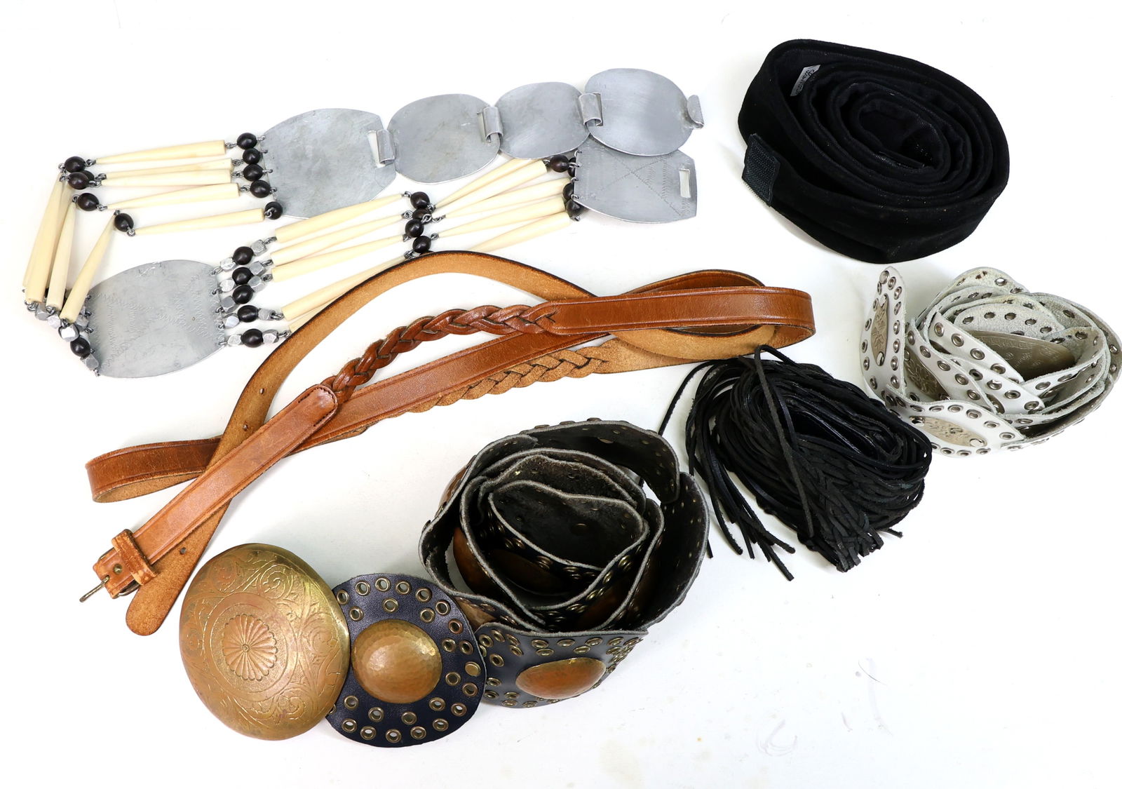 Decorative Belts: Includes belts with metal accents, such as silver- and gold-tone oval designs, braided leather straps, and a black velvet belt, features materials such as leather, metal, and synthetic components. Bel