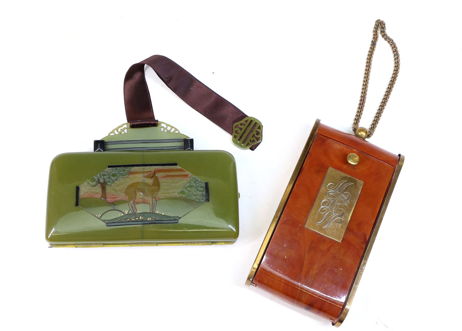 Plastic and Metal Compact Cases: Compact cases made of green and orange plastic with metal accents. The green case features an inset deer motif and a brown fabric strap. The orange case has a monogrammed metal plate and a chain handl