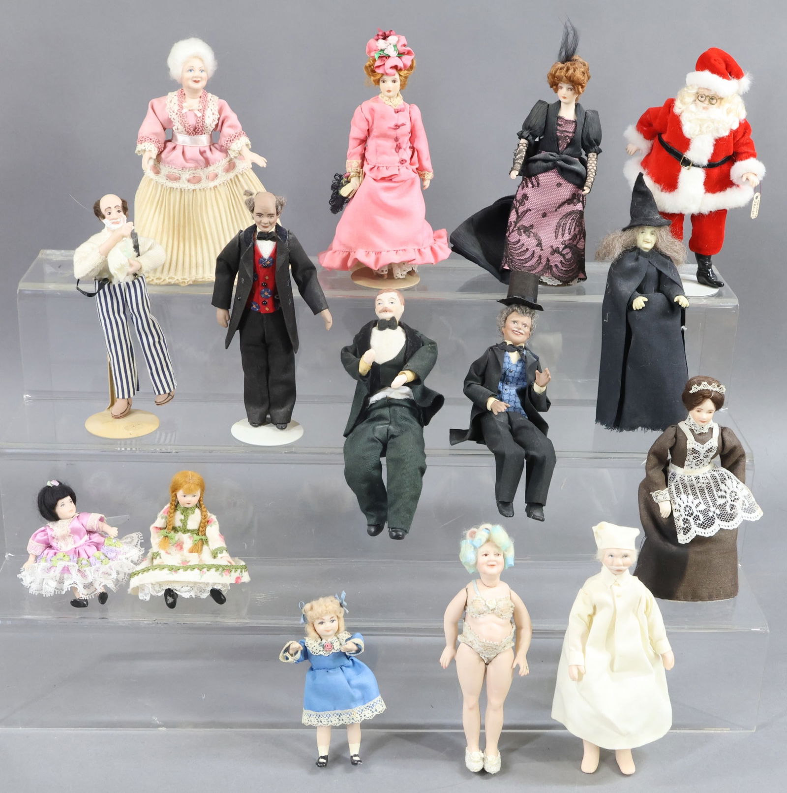 MINIATURES.: LOT of (15) contemporary bisque dollhouse dolls. (3) Female Children. Santa. Witch. (5) Males. (5) Females. (6) Stands. This lot is being sold AS IS.