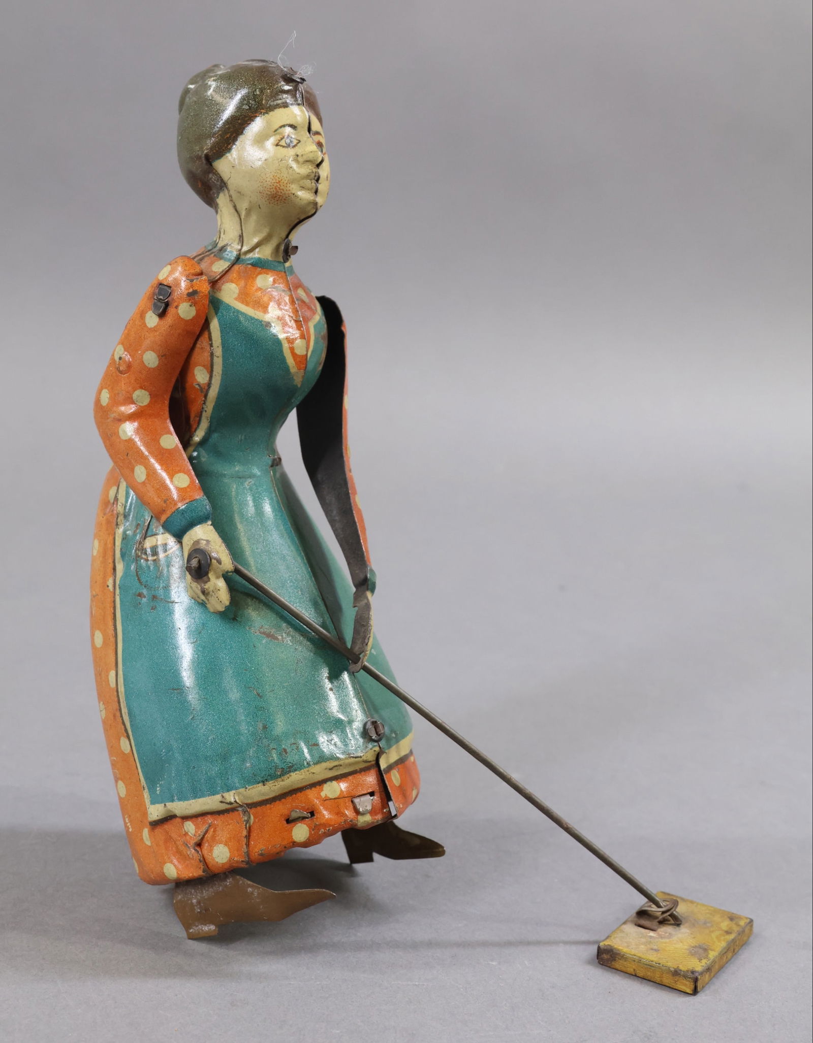 VINTAGE TOYS.: 7" T. Tin "Busy Lizzy" wind up toy. Made in Germany. When wound, lady pushes her sweeper. Condition: works sporadically. Possible repaint in hair area on left side of head. This lot is being sold AS I