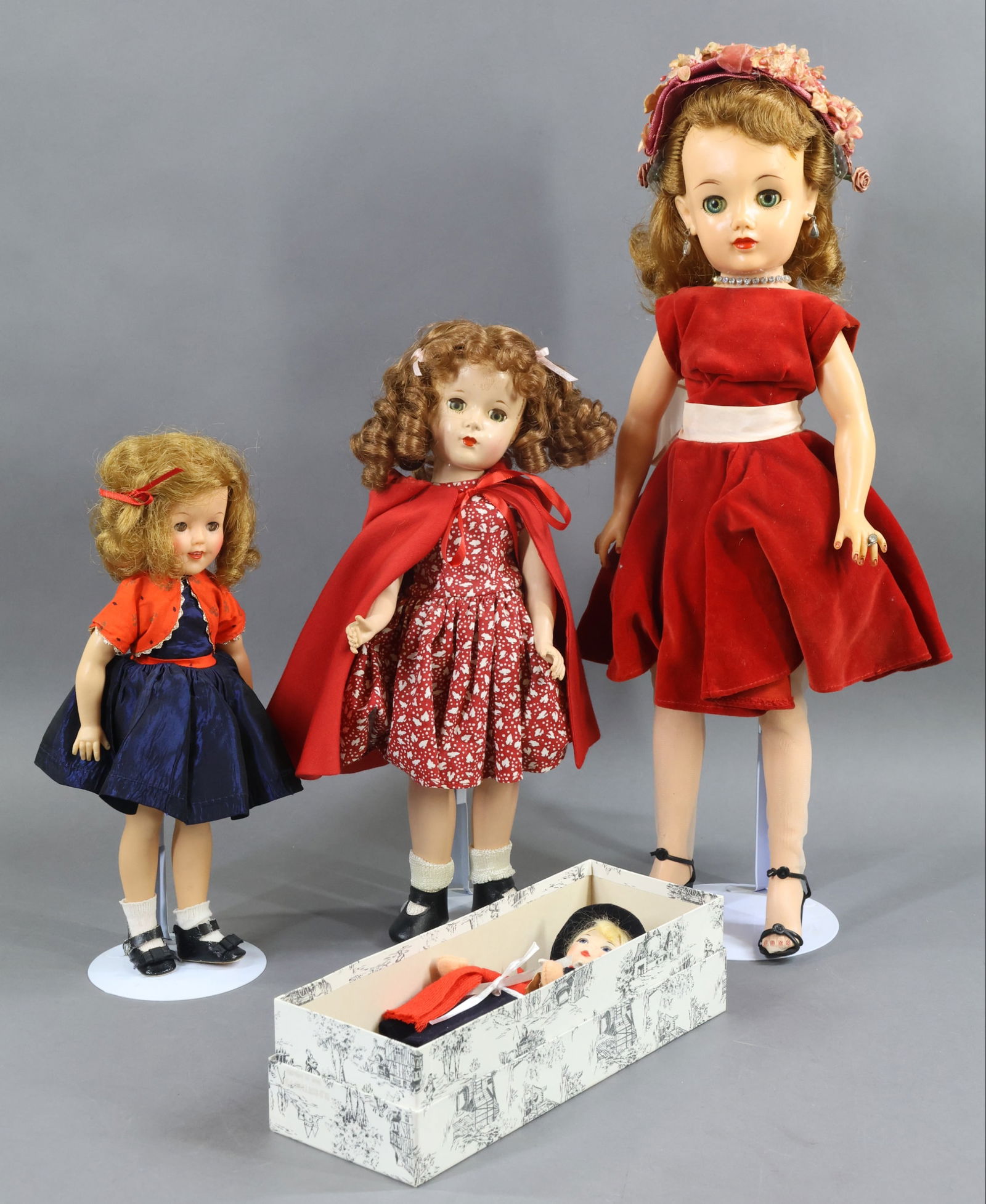 1950's-1970's DOLLS.: LOT of (4) dolls. MIB 8" "Old Cottage Doll". 12" IDEAL vinyl "Shirley Temple". Original tagged outfit, replaced shoes. 14" Unmarked HP doll with the Margaret O'Brien face. Dressed as Little Red Riding