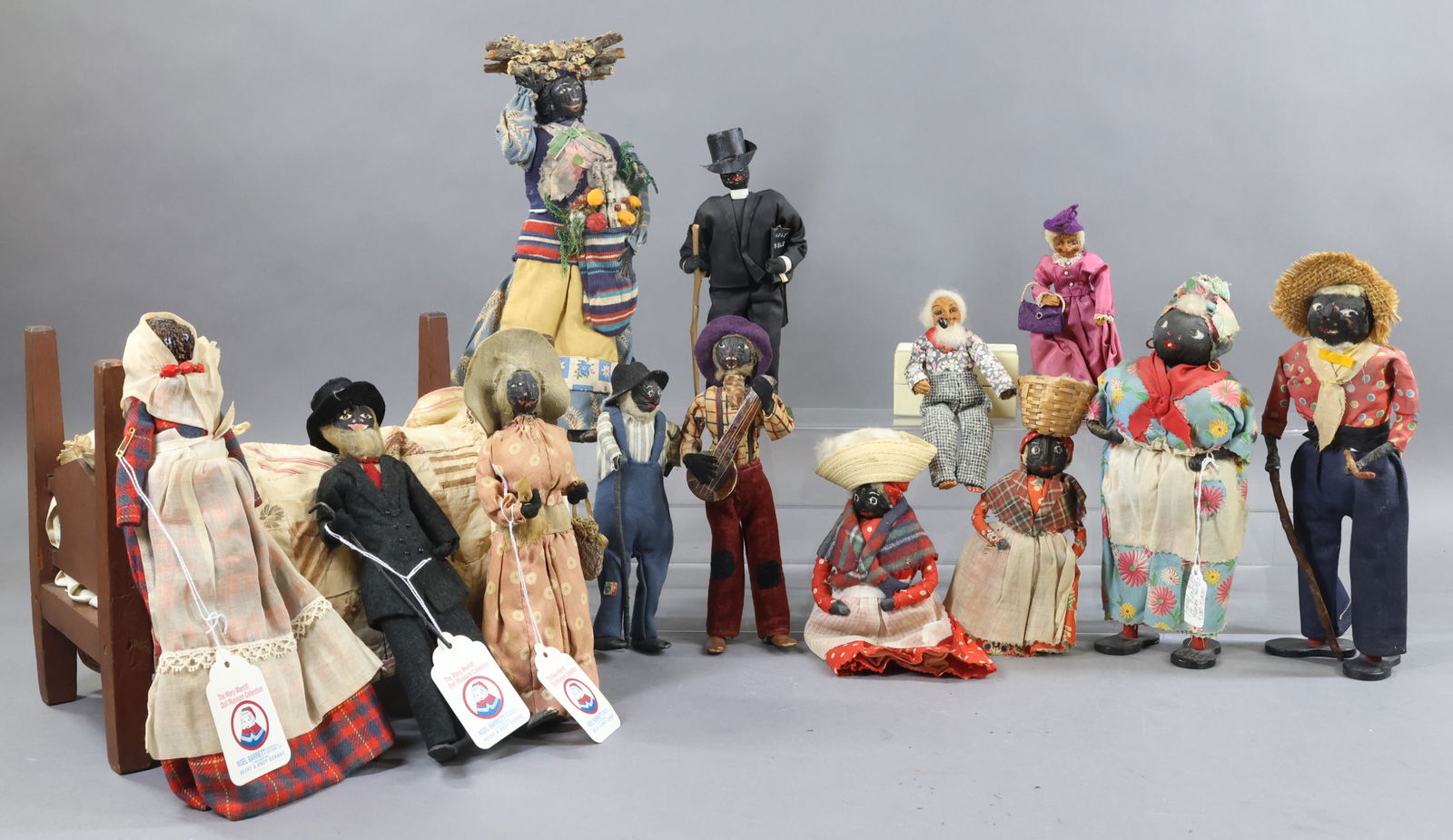 BLACK DOLLS.: LOT of dolls. (8) Loveleigh/type dolls with painted walnut/nut heads. Some of these were sold at the Mary Merritt Doll Museum Collection auctions. One lot came with an antique wooden four poster bed w