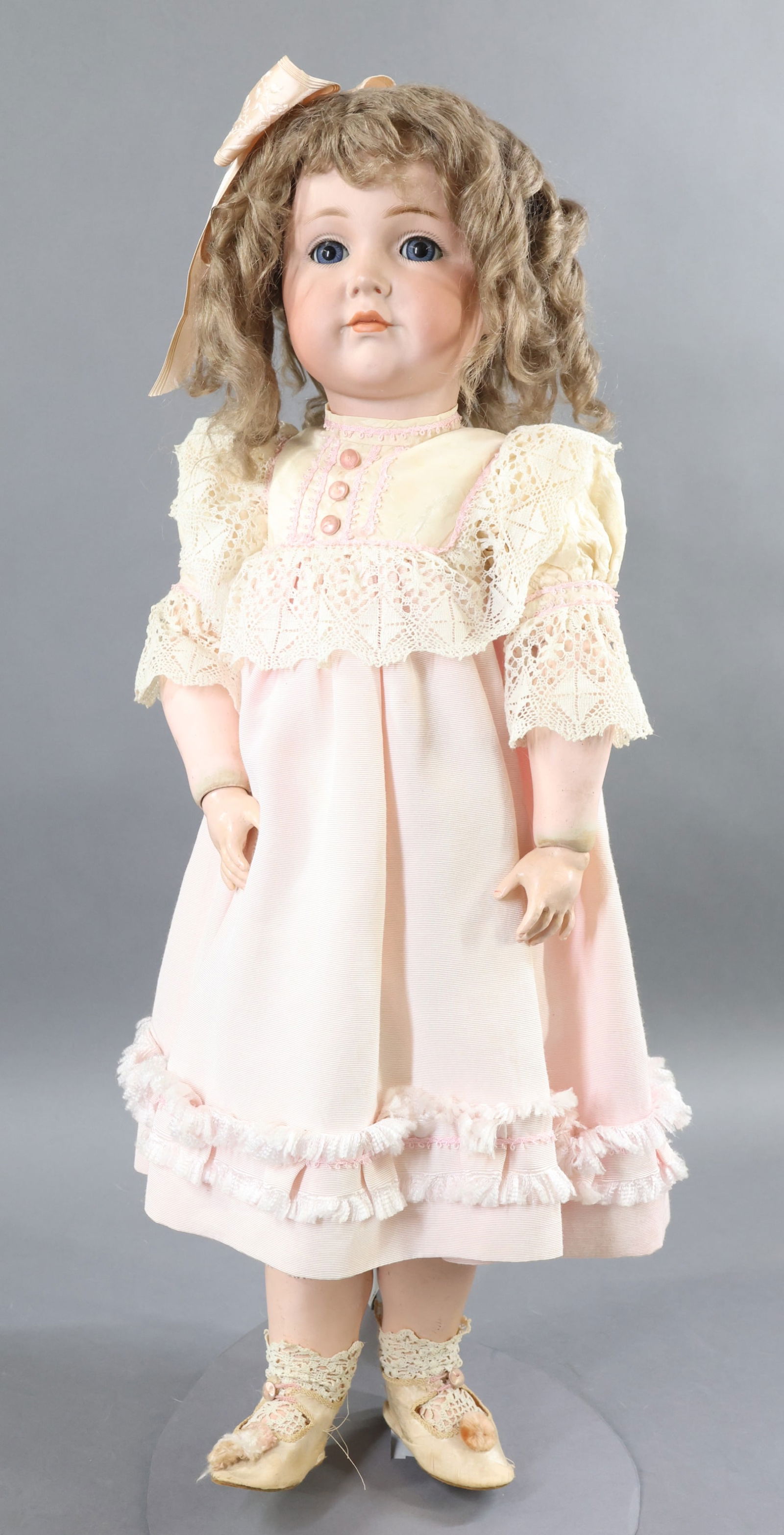GERMAN BISQUE DOLLS.: 25" K * R SIMON & HALBIG 117 62 Character Doll. Blue sleep eyes, closed mouth, curly tosca mohair wig. Papier mache ball jointed body. Redressed in attractive pink faille dress with antique lace and s