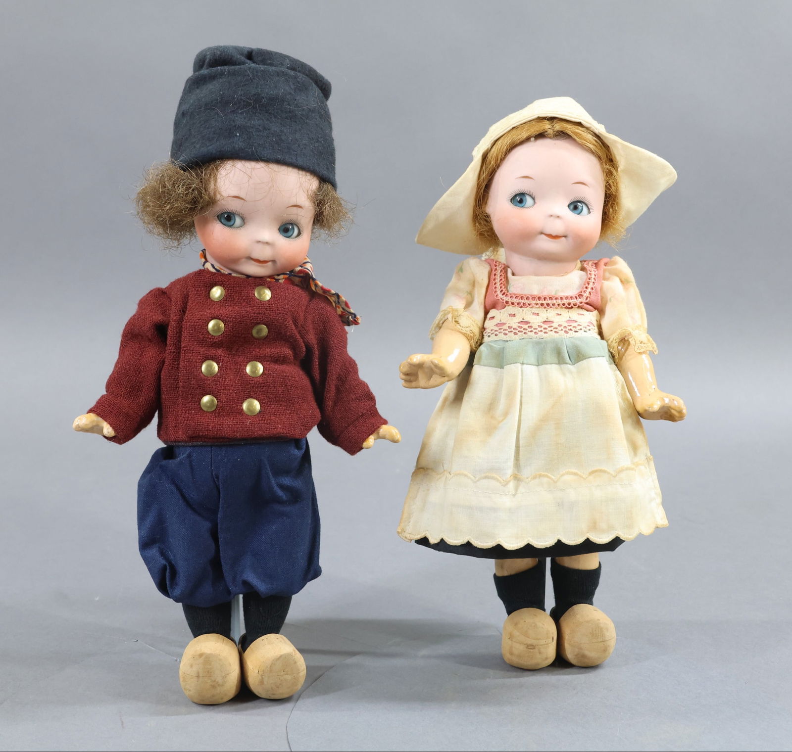BISQUE GOOGLY EYE DOLLS.: Pair of 9 1/2" Googly-eye dolls marked 241. Blue side glance eyes, closed mouth with watermelon smiles. She has a short honey blonde HH wig; he has a brown HH wig. 5 Pc. papier mache bodies. Dressed a