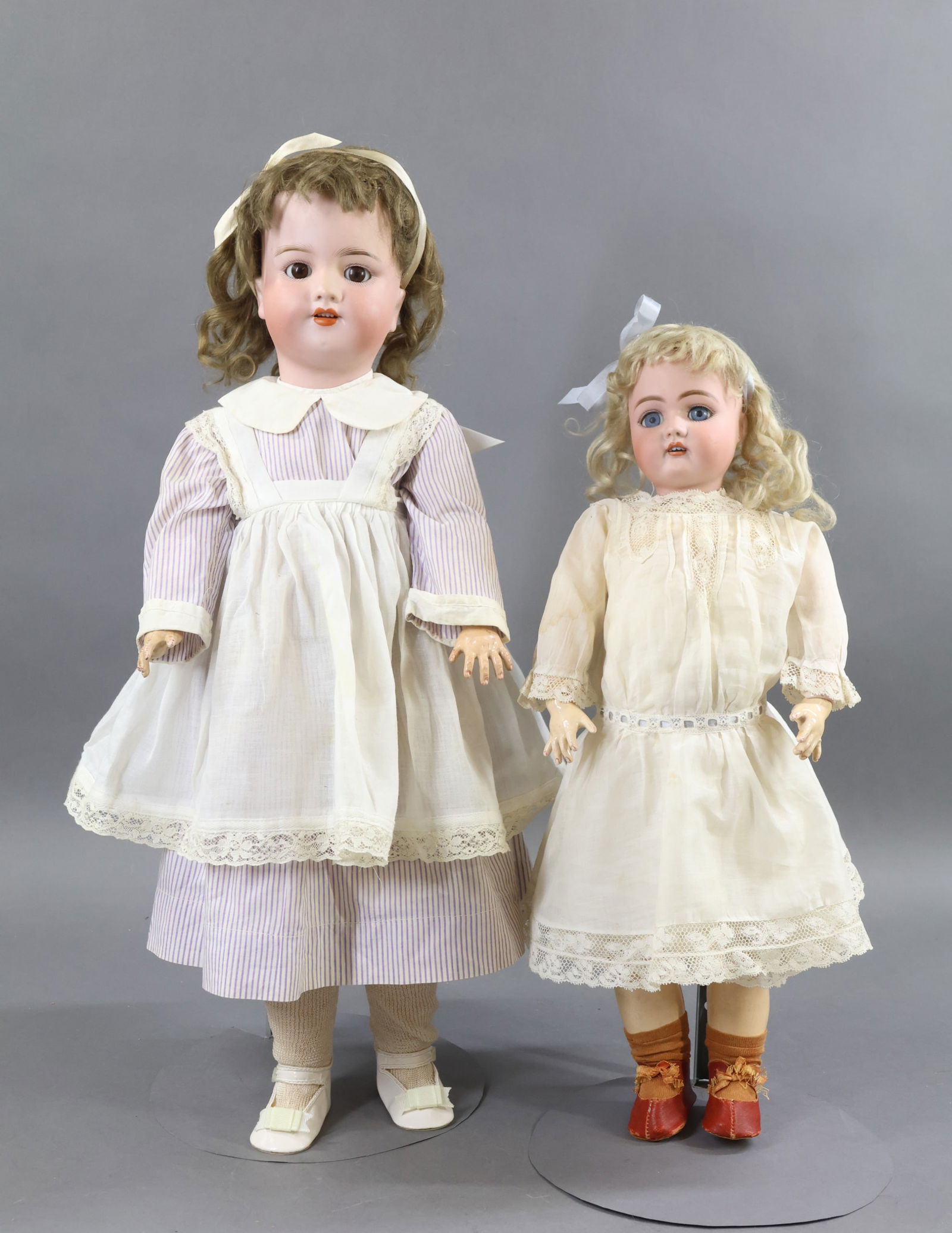 GERMAN BISQUE DOLLS.: Pair of dolls. Both dolls have sleep eyes, open mouths, mohair wigs, papier mache jointed bodies. They are dressed in antique clothing. Doll 1) 19" 79 10 GERMANY HANDWERCK. Blue eyes, pierced ears, pa