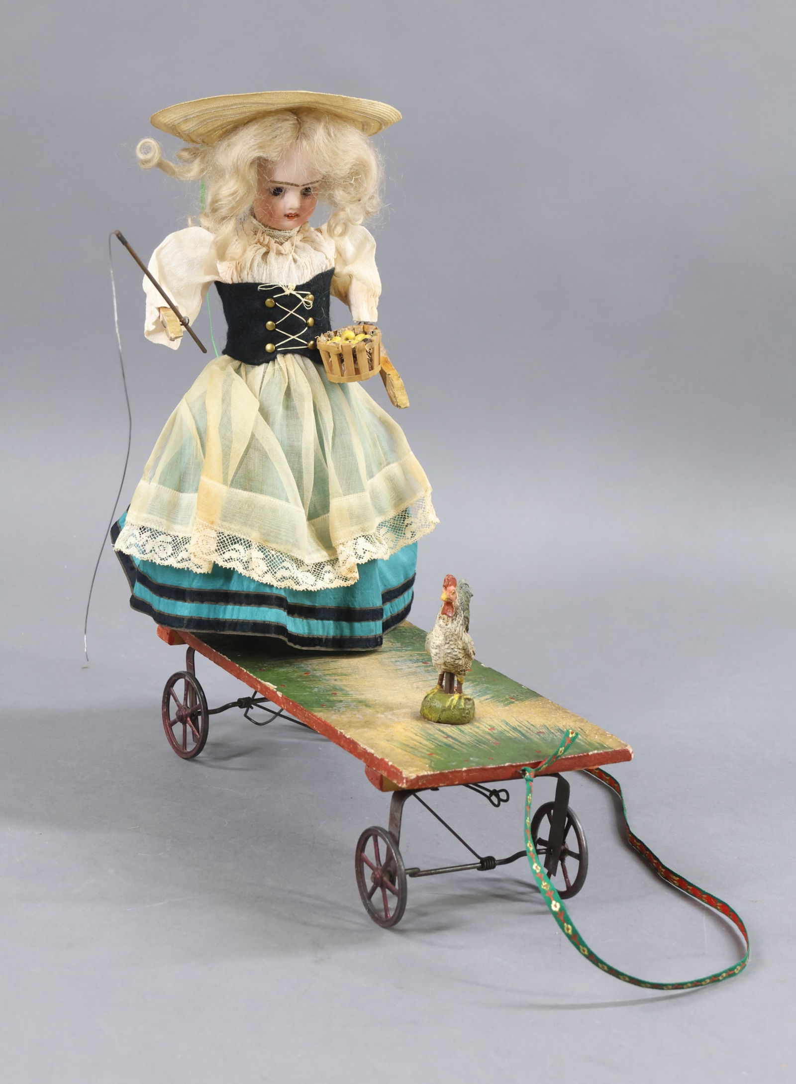 TOYS - ANTIQUE.: Antique Platform Pull Toy. 10" J V (anchor symbol) FRANCE 00M bisque head doll Stationary brown eyes, open mouth, blonde mohair wig. Wire armature body with wooden lower arms and papier mache lower le