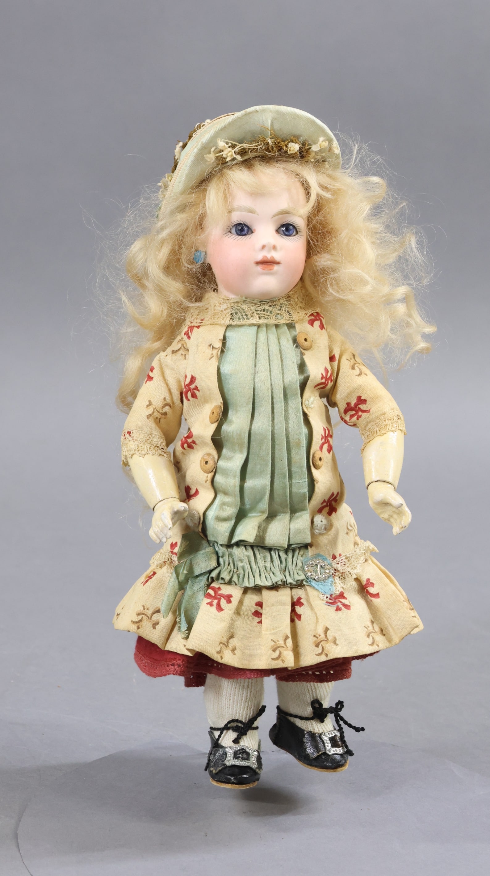 ANTIQUE FRENCH BISQUE HEAD DOLL.: 9" (Incised) BRU JNE 1 petite size doll with blue paperweight eyes, closed mouth, pierced ears, long pale blonde curled mohair wig, cork pate. Papier mache jointed body with separate hands. Dressed in