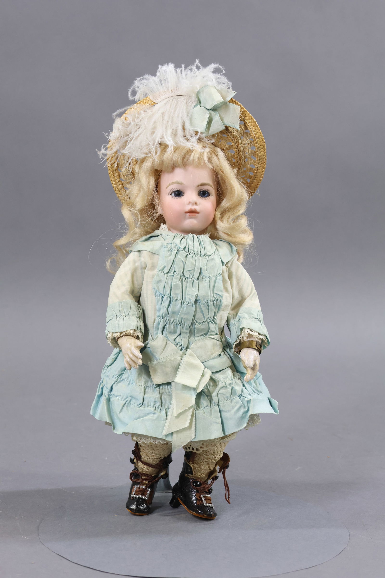 ANTIQUE FRENCH BISQUE HEAD DOLL.: 10" (incised) BRU JNE 0 petite doll with blue paperweight eyes, closed mouth, pierced ears, long curly blonde mohair wig, cork pate. Papier mache jointed body is marked (paper label) ".... MAIN BLEU P