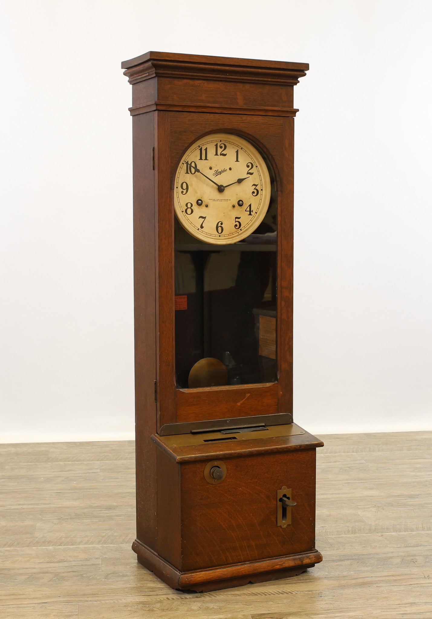 Simplex Time Recorder Clock: Recorder Model 1223, Serial No. 17679. Oak case with morning, afternoon, and extra time recording mechanisms, and pendulum. Early 20th c. 48"h x 15"w x 12"d