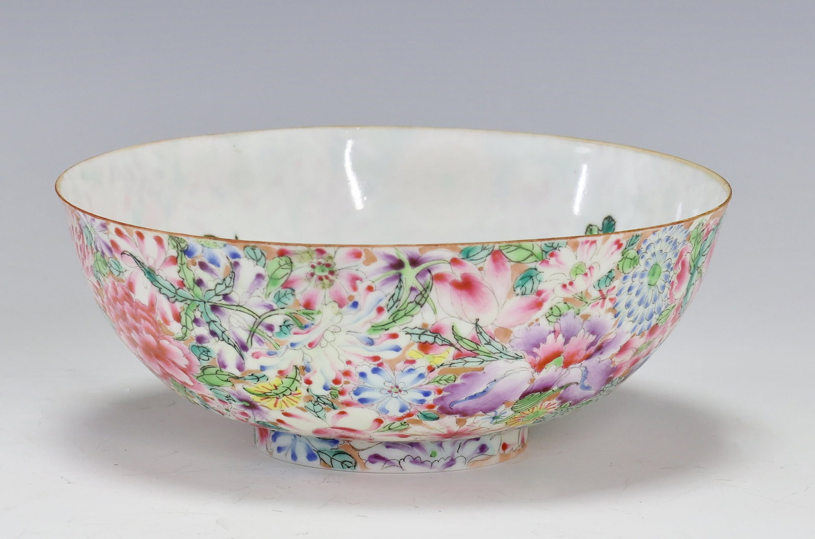 Chinese Famille Rose Eggshell Porcelain Bowl: Qing - Republic era bowl decorated to the exterior with the Mille Fleur motif, and to the interior with sprigs of flowers. Spurious four-character Qianlong reign mark to the foot. 2.25"h x 5.75"w