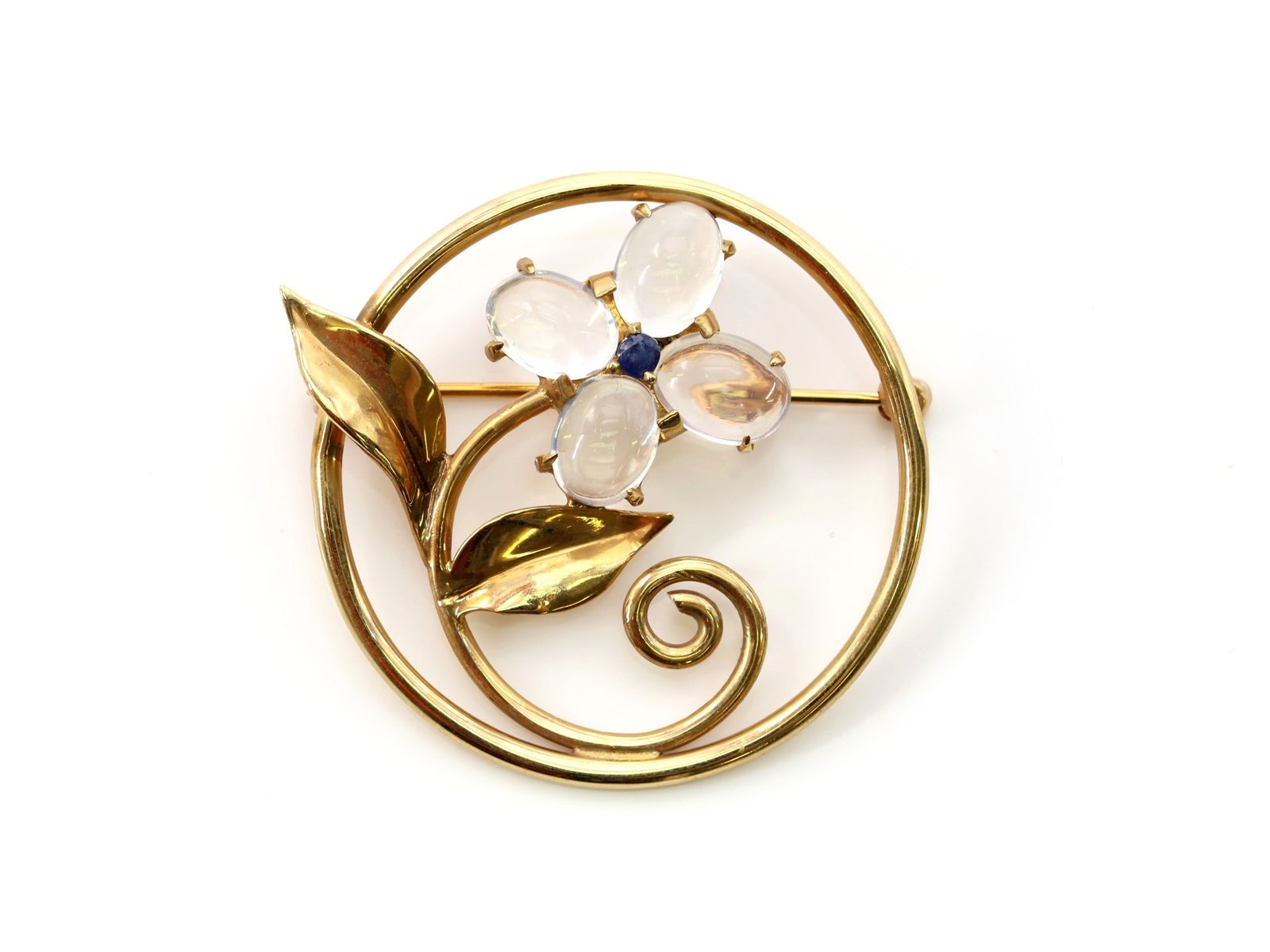 14K YG Moonstone Sapphire Brooch: Circular floral brooch set with four 8mm moonstone cabochons and a central sapphire accent. Diameter 1.5", total weight 4.5 dwt.