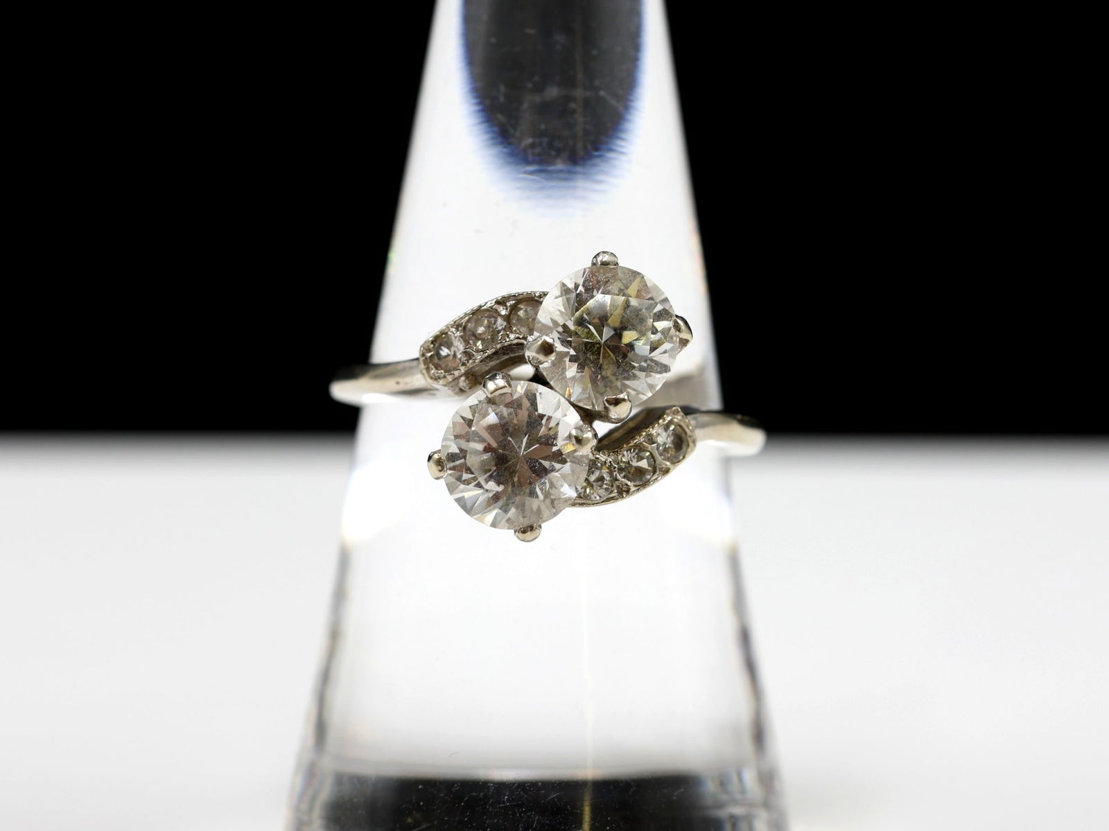 14K WG Spinel Ring: Bypass ring set with two round white spinels, each approximately 1.9 carats, accented by smaller spinel stones. Size 7.75, total weight 2.8 dwt.