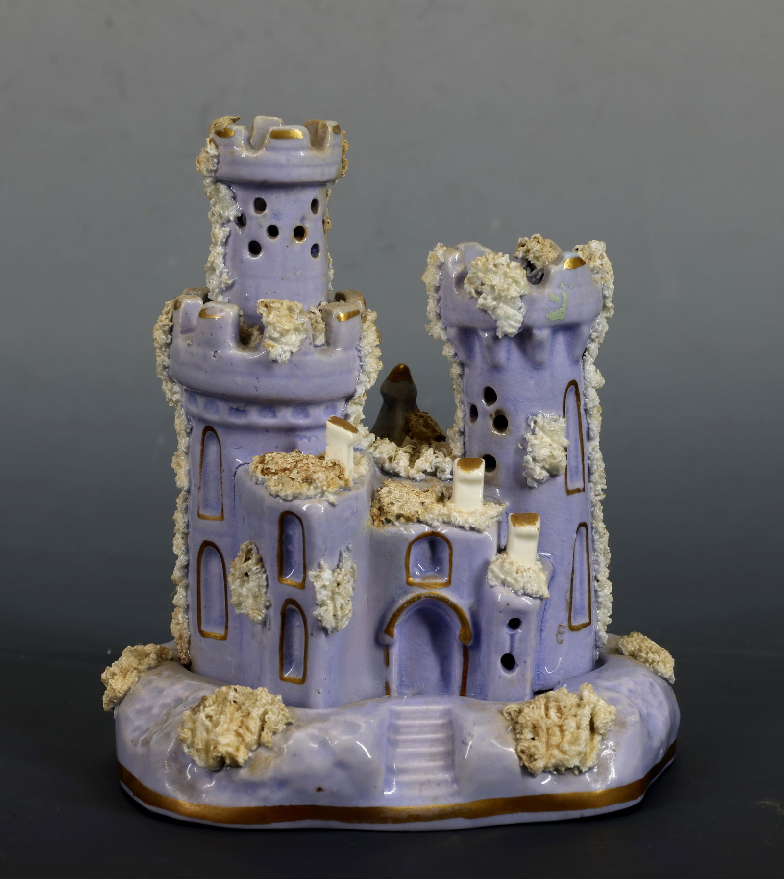 Staffordshire Pastille Burner: Staffordshire pottery pastille burner modeled as a castle with twin towers and battlements, decorated in lilac glaze with gilt accents and applied white “moss” ornamentation. Circa 1830. 5.25"