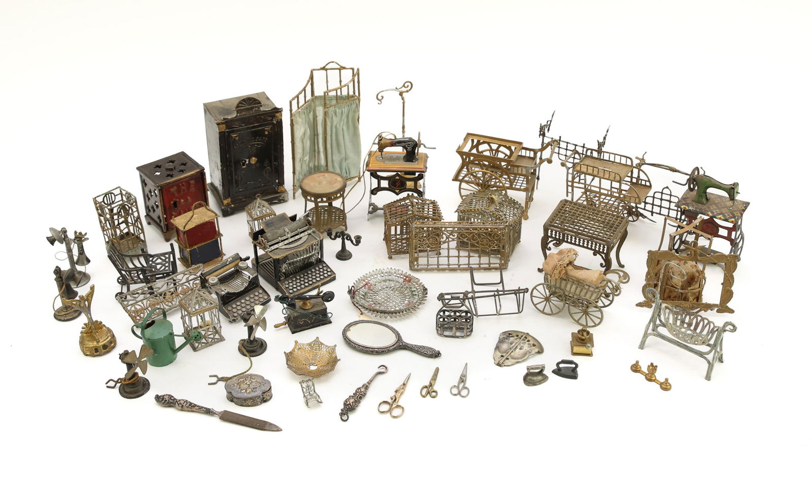 Miniature Doll Housewares: Consists of brass birdcages, tea carts, and lattice tables; safes, typewriters, telephones, sewing machines, scissors, a vanity mirror, and more. Condition varies.