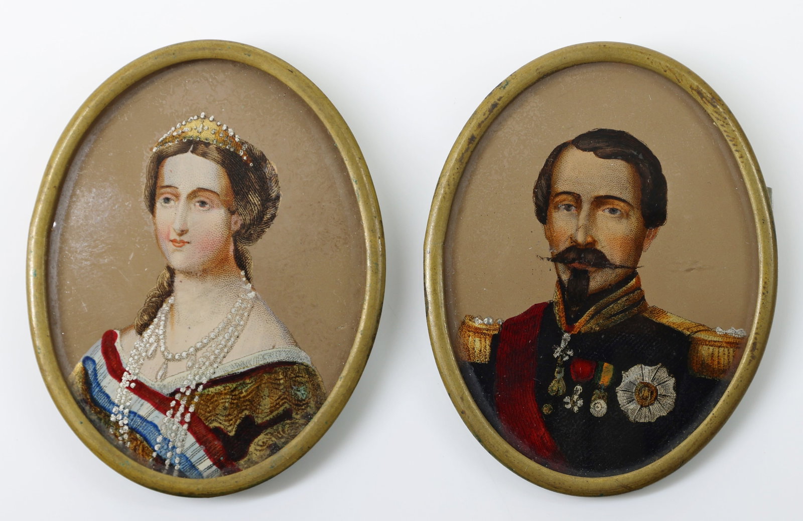 Napoleon and Empress Eugenie Miniatures: Pair of lithographs on tin with embellishments of gilt and enamel. Depicts Napoleon III in military uniform, the National Order of the Legion of Honour pinned to his breast. Empress Eugenie wearing Fr