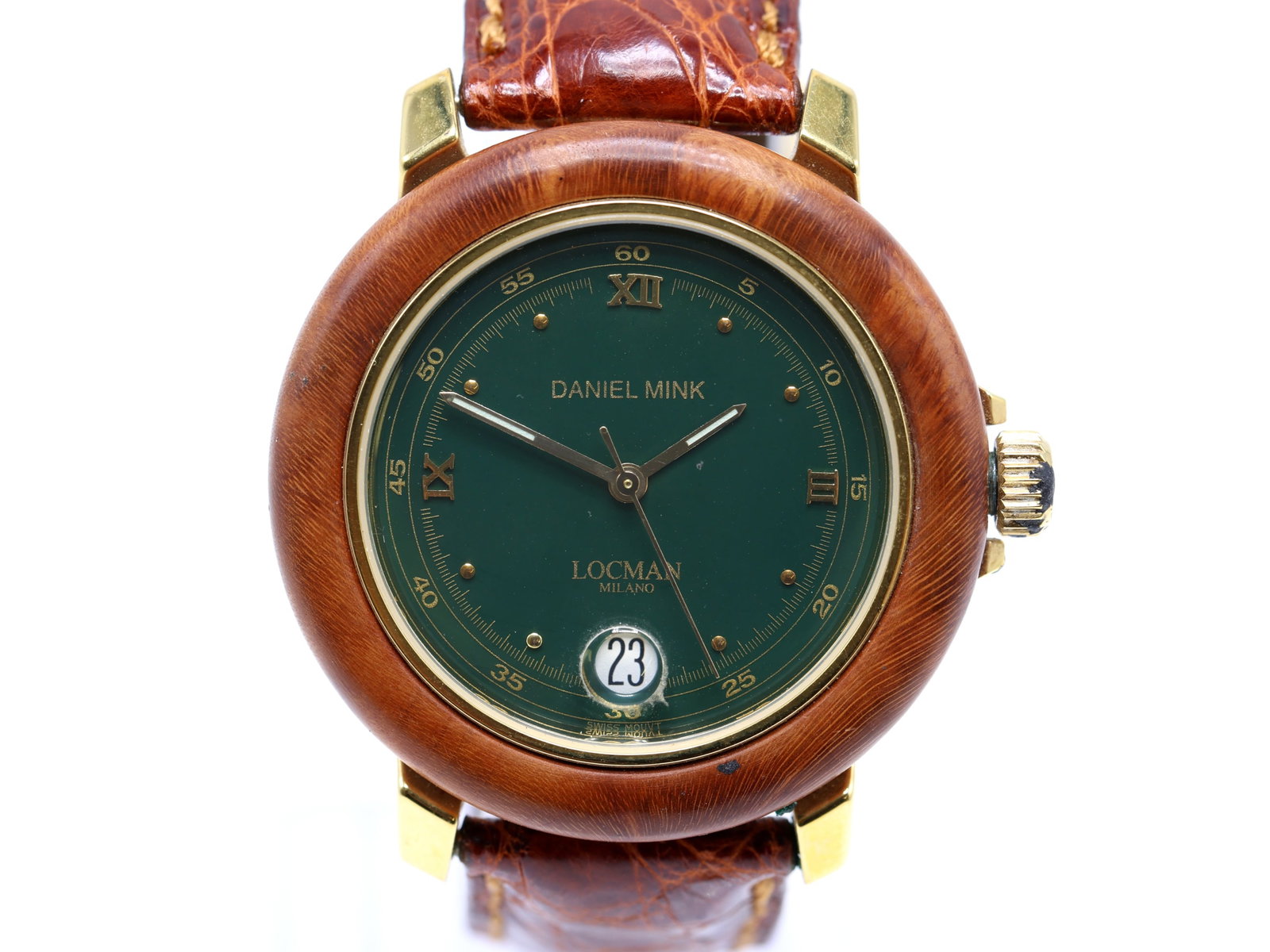 Daniel Mink by Locman, Wood-Cased Quartz Wristwatch: Wood encased round case with gold tone lugs and crown, approx. 40mm, green dial with applied Roman numerals and dot markers, date display at 6 o’clock with magnifier, and printed Daniel Mink and Loc