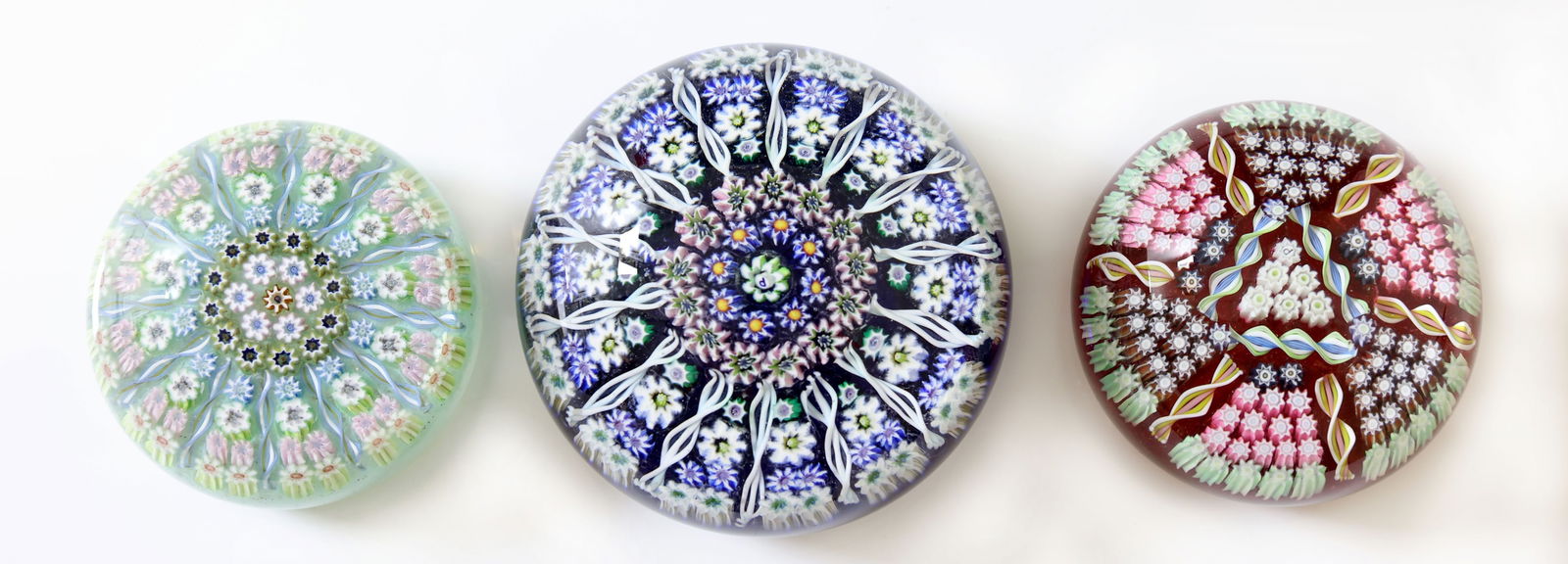 Perthshire Millefiori Paperweights: Millefiori glass paperweights by Perthshire, the largest marked with the signature "P" cane and labeled, a smaller example with the "P" can and unlabeled, and the other smaller example labeled but not