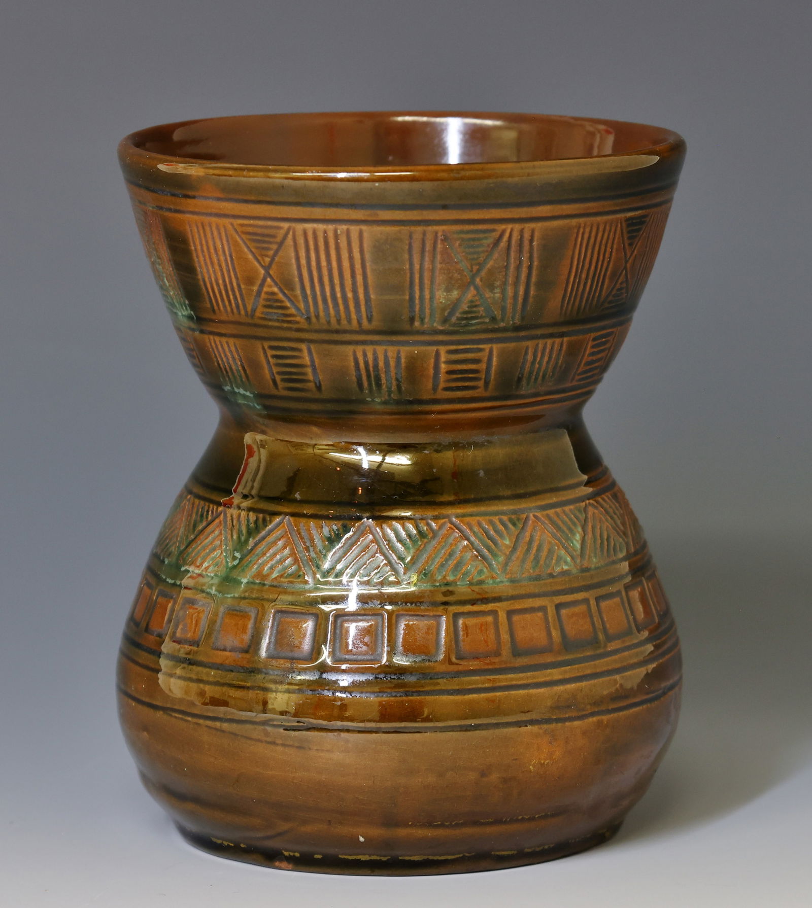 Christopher Dresser for Linthorpe Pottery Vase: British Orientalist art pottery vase, hourglass form with incised geometric bands reminiscent of Indian motifs, in a glossy brown and mottled green glaze. Impressed "Linthorpe" and "Chr. Dresser", wit