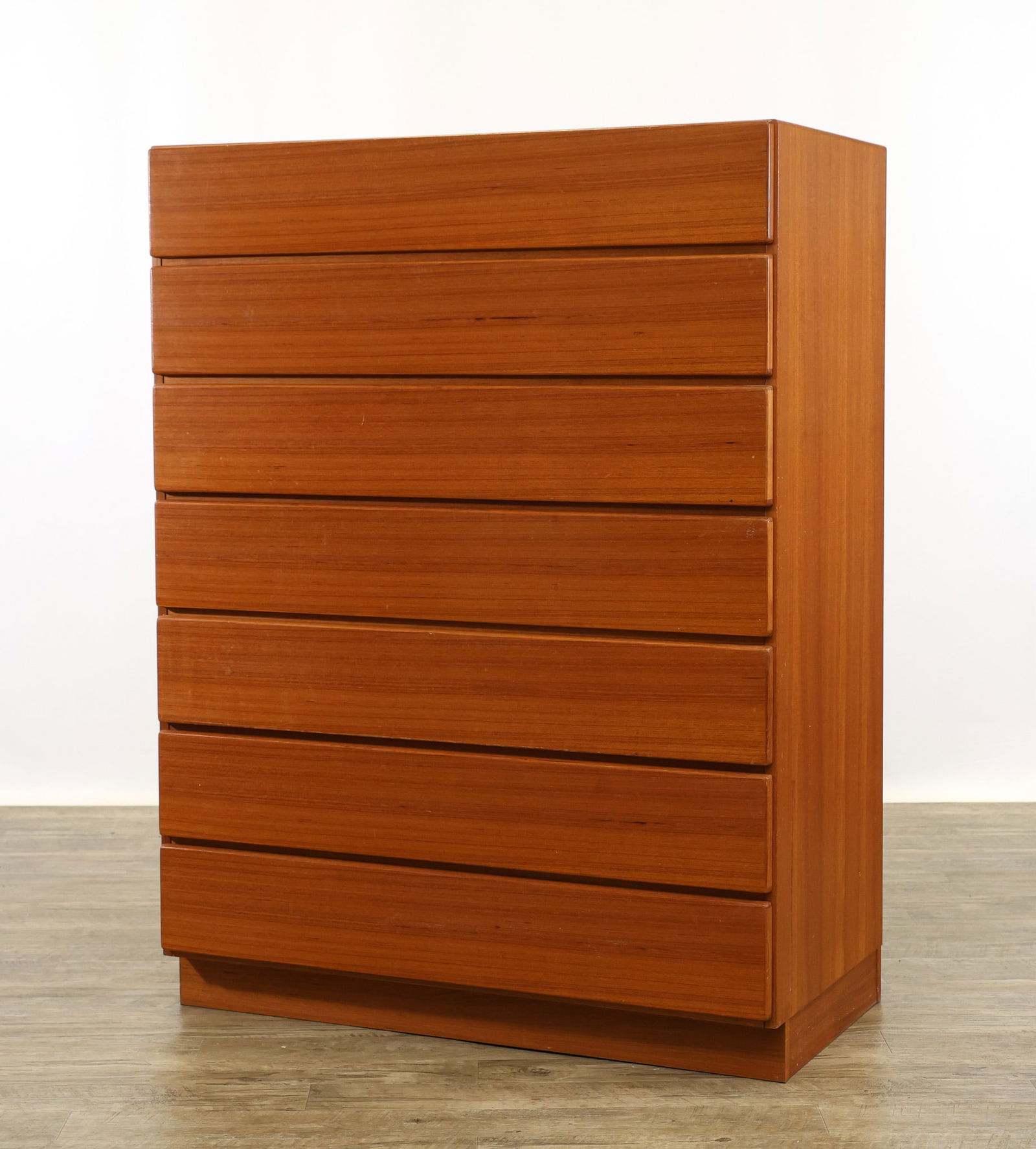 Danish Teak High Dresser: Teak high dresser with seven drawers, raised on a plinth base. Unmarked. Light surface wear. 48"h x 36"w x 19"d