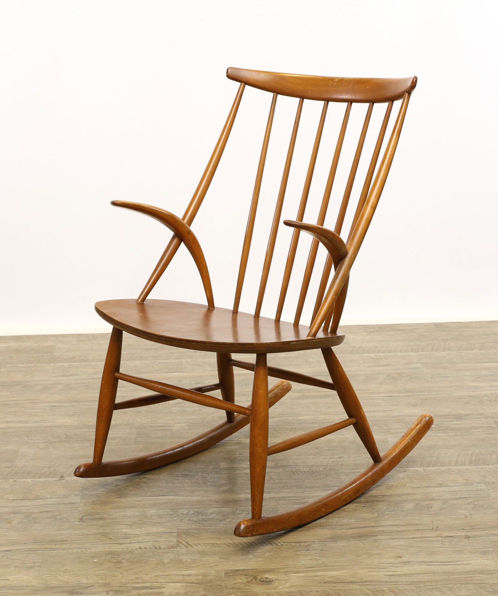 Illum Wikkelso for Niels Eilersen IW3 Rocking Chair: Danish Modern oak chair with cigar legs and stretchers on shaped rockers with a plank seat, curved spindle back and boomerang arms. No markings noted. Shrinkage cracks to the underside of the seat; su