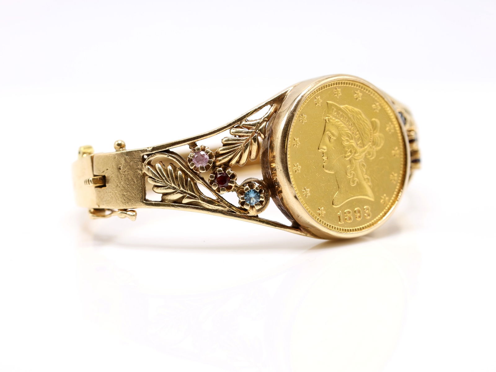 14k 1893 $10 Liberty Head Gold Coin Bracelet: 14k yellow gold bracelet mounted with an 1893 $10 Liberty Head gold coin and gemstone accents, openwork foliate links, 6.5" and 31.4dwt.