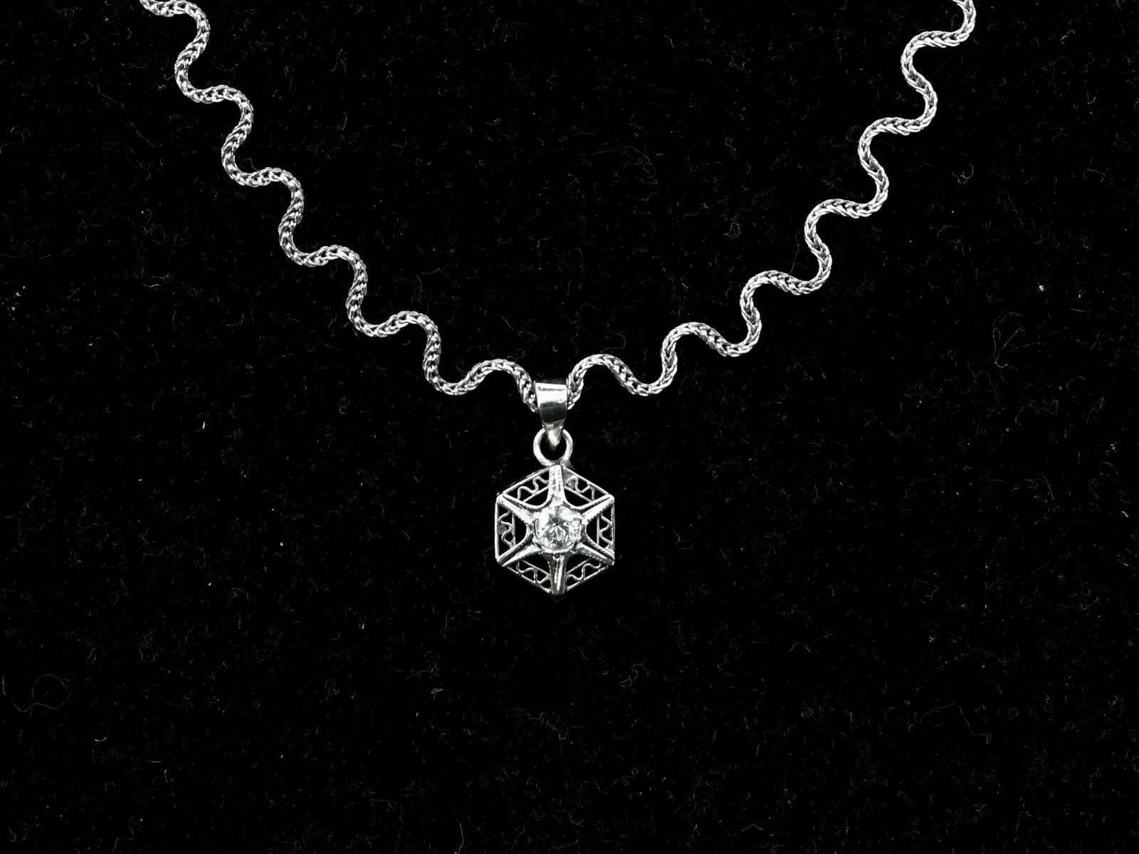 14k WG Diamond Necklace: 14k white gold openwork pendant set with a round brilliant cut diamond, suspended from a matching white gold chain. Necklace length 17.75". Total weight 3.2dwt.