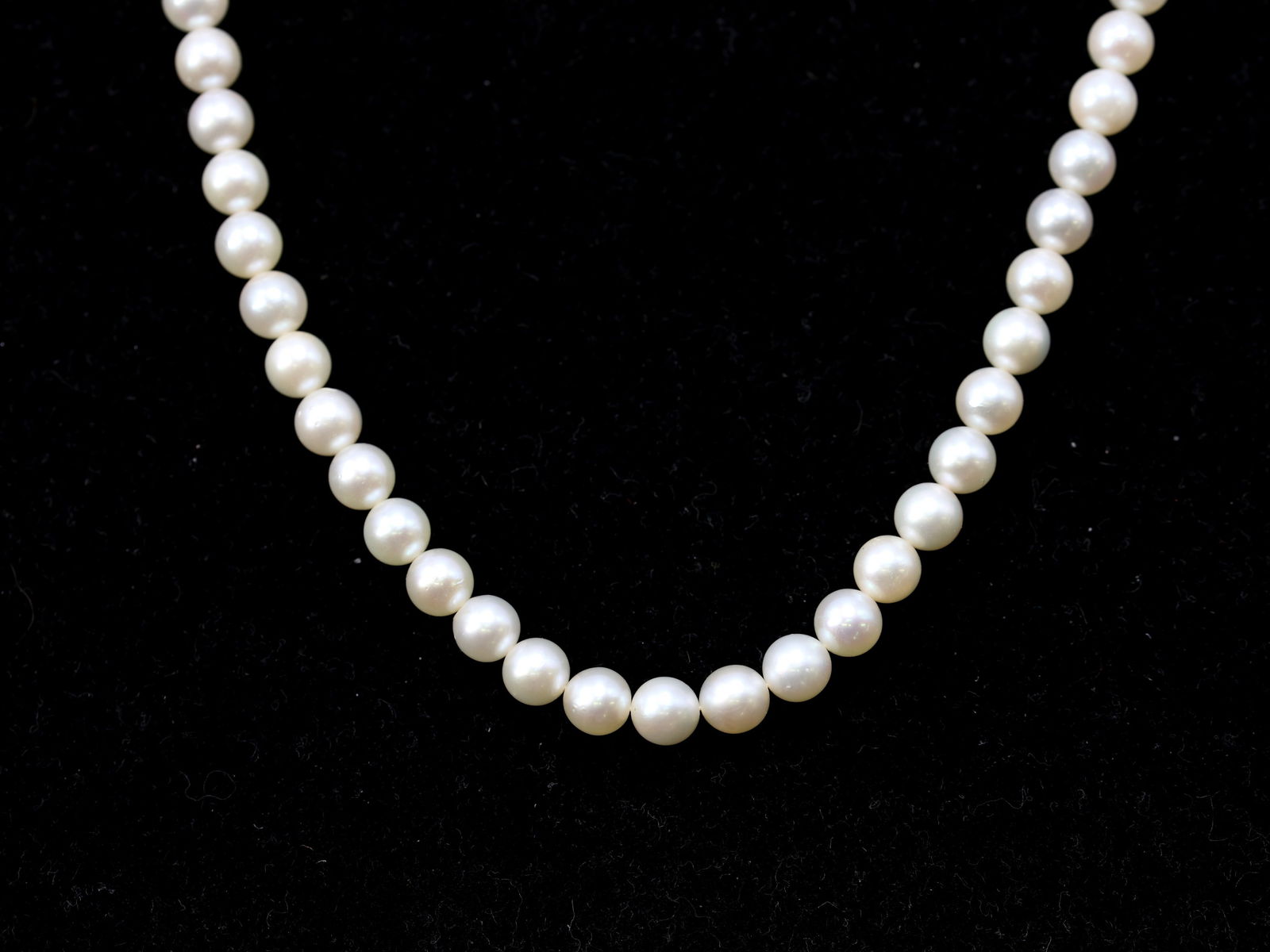 Mikimoto Pearl Necklace: Mikimoto cultured pearl necklace composed of graduated pearls measuring approximately 5.5mm to 6.0mm, 22" long, with Mikimoto sterling silver clasp, accompanied by the original Mikimoto presentation