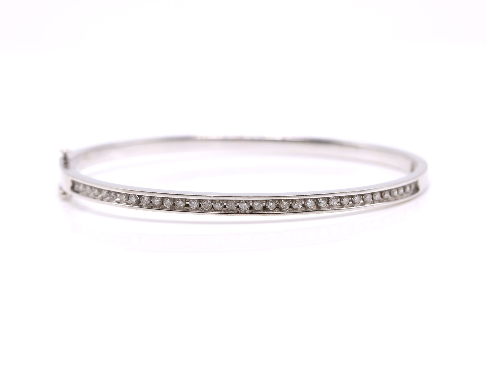 14k WG Diamond Bracelet: 14k white gold diamond bangle bracelet set with approximately 1.00 carat total weight of round cut diamonds in a channel setting. 6.75" and 10.9dwt.