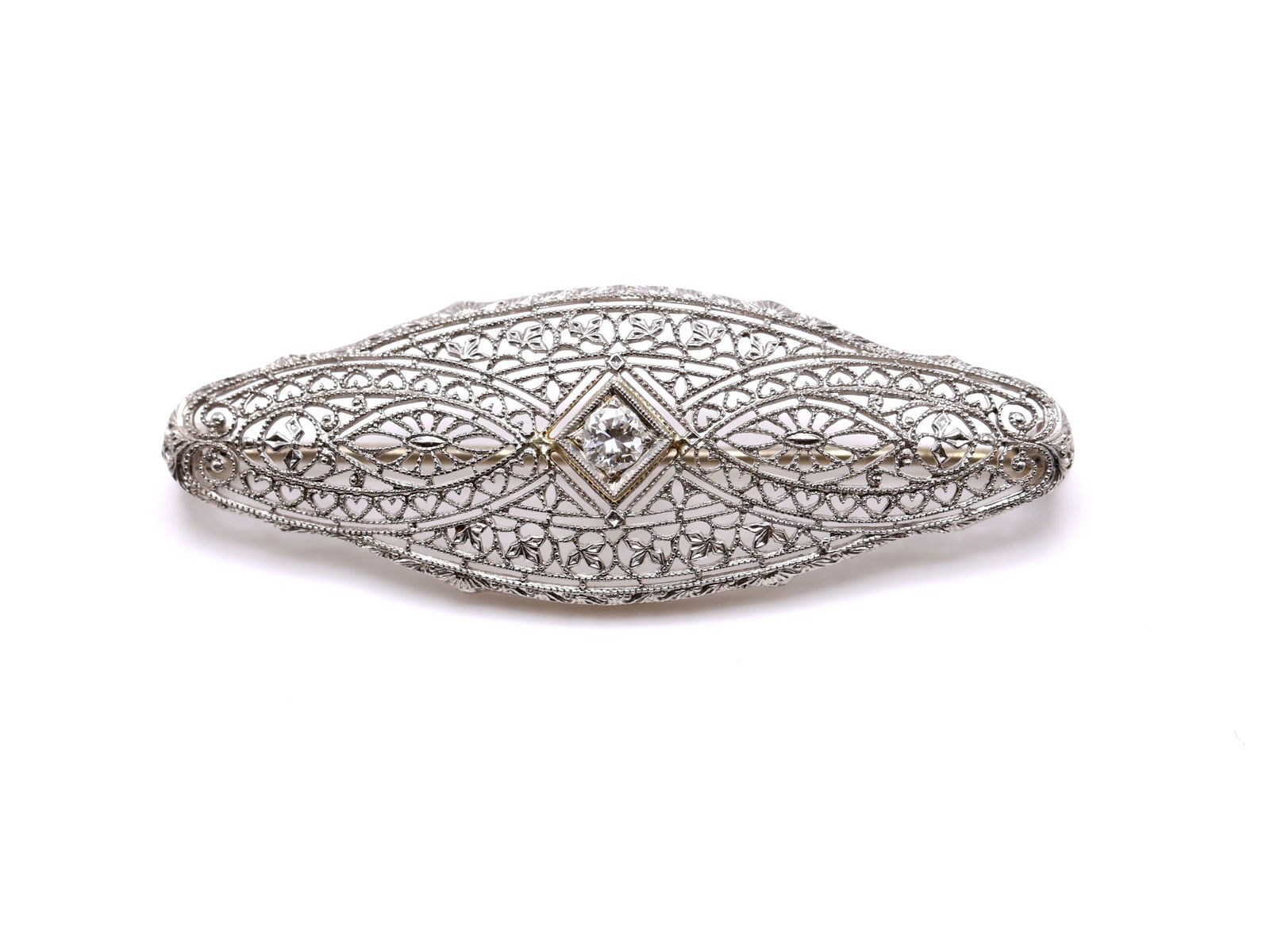 14k WG Diamond Pin: 14k white gold filigree diamond pin set with a round brilliant cut diamond weighing approximately 0.10 carat, openwork design with milgrain detailing. Measures 1.75" in length and weighs 2.3dwt.