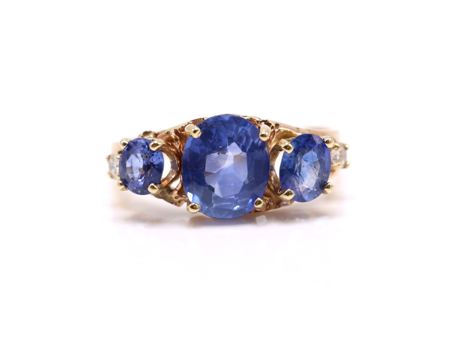 14k YG Sapphire Ring: 14k yellow gold three stone sapphire and diamond ring set with an oval cut sapphire weighing approximately 1.75 carats, flanked by oval sapphires weighing approx. .50 carats and .33 carats, accented b