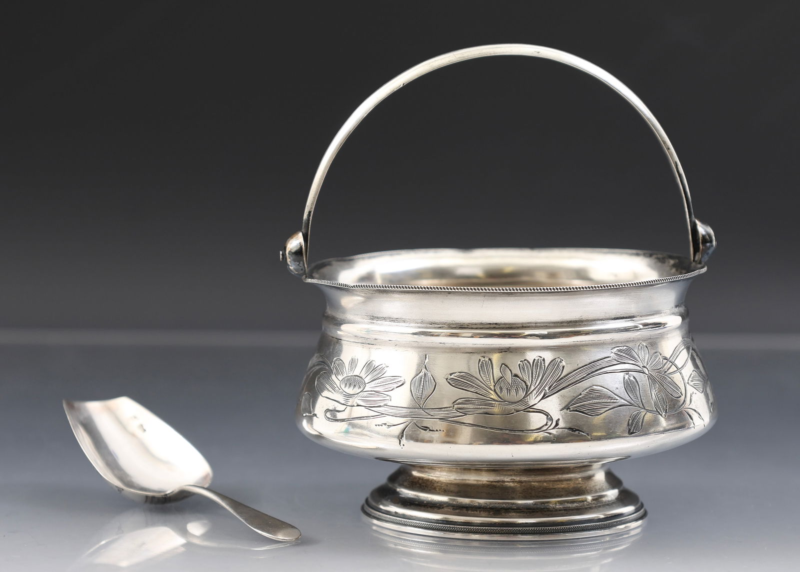 Imperial Russian Silver Sugar Basket and Scoop: 84 zolotnik (875 silver) sugar basket and scoop. The basket with bail handle, niello floral decoration, marked to the foot with the 1899 - 1908 kokoshnik for assayer Ivan Lebedkin, Moscow, with obscur