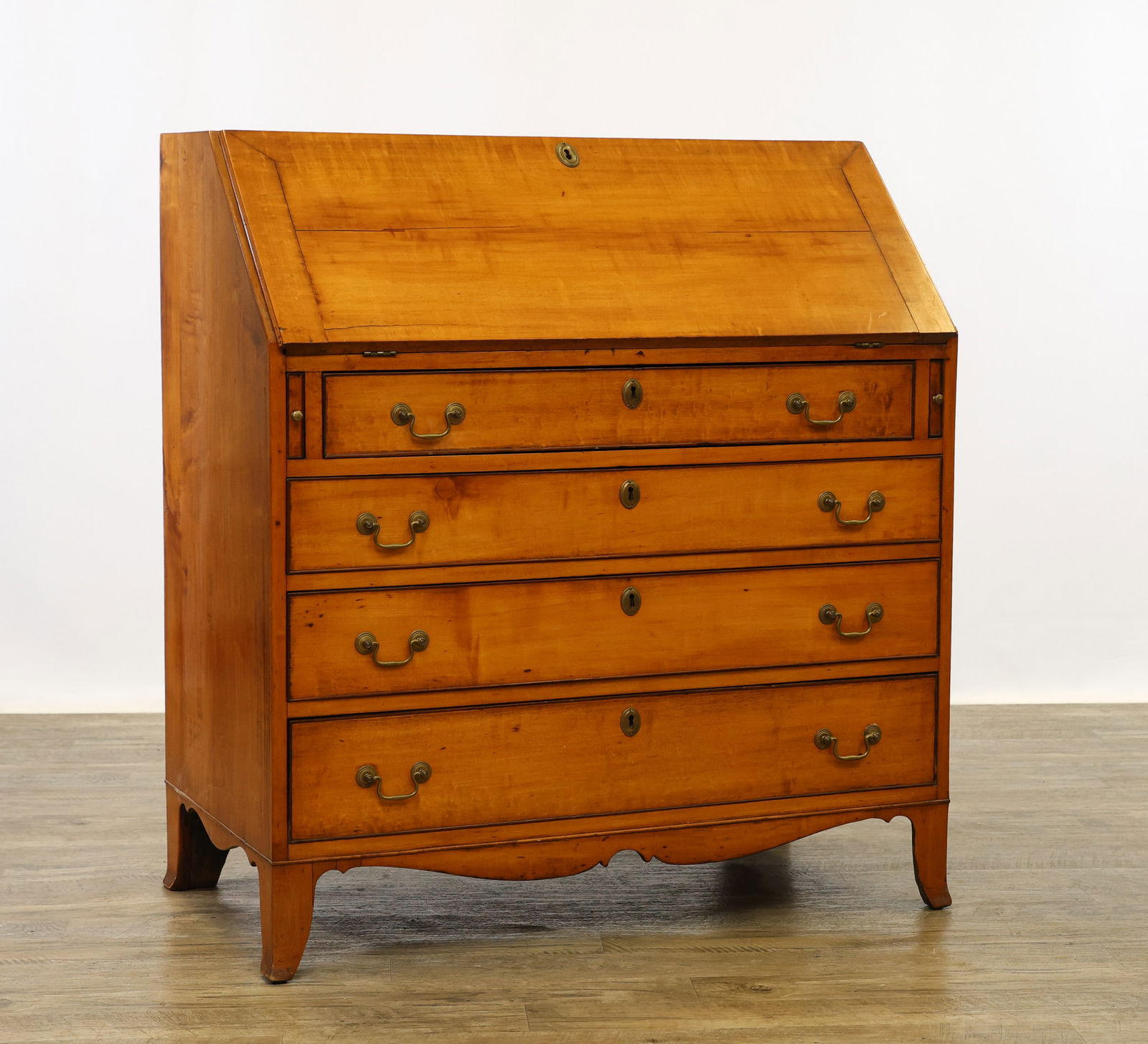 Hepplewhite Maple Slant-Front Desk: Dovetail top opening to a fitted interior and writing surface, four graduated drawers, shaped apron on French feet. 41"h x 37.5"w x 20"d (34.5"w open)