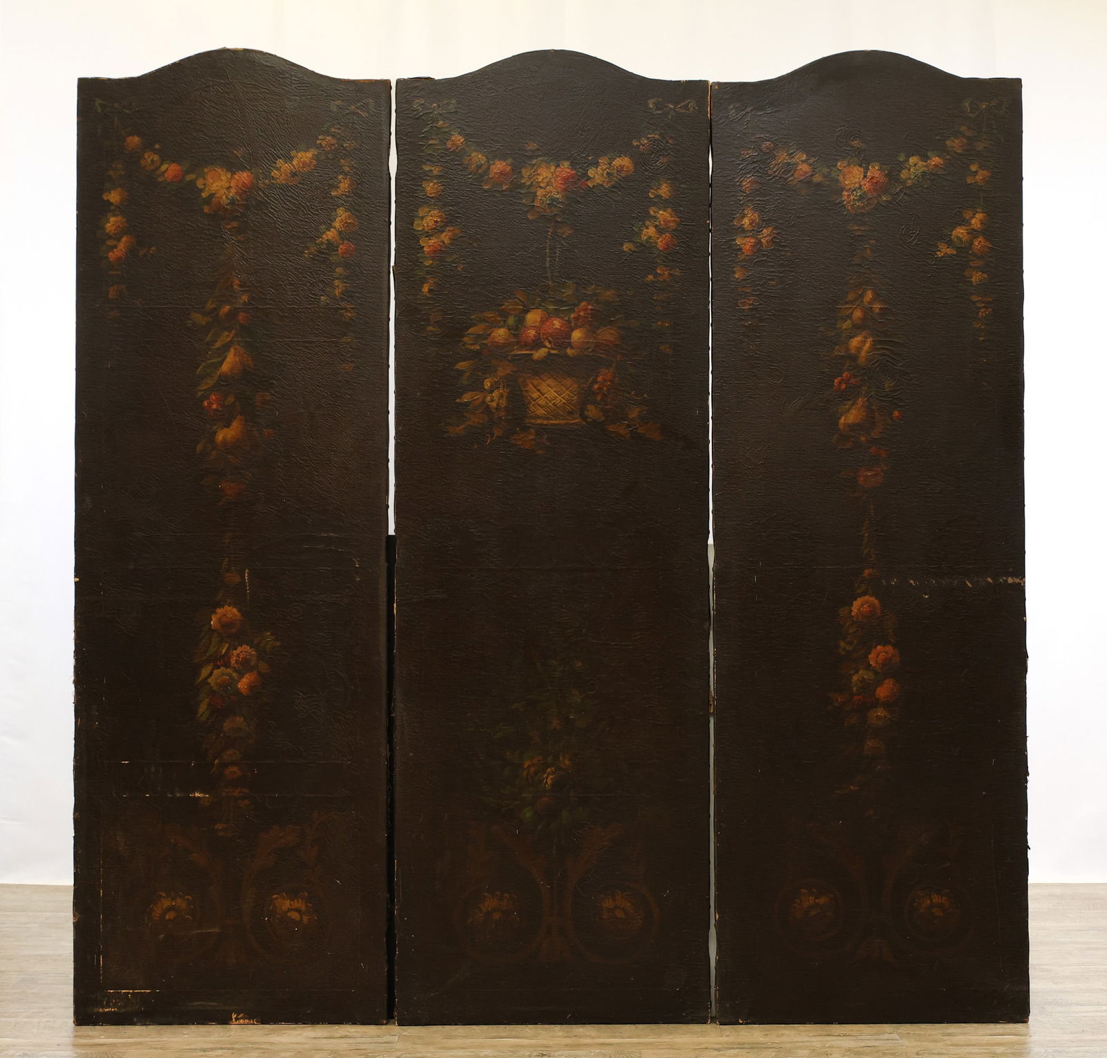 European Leather Three-Panel Botanical Screen: Three-panel hand painted festoon floral, ribbon, and fruit motifs on leather. Early 20th c. Areas of wear and loss to leather, panels are loose and separated and will need assembly hardware. 72"h x