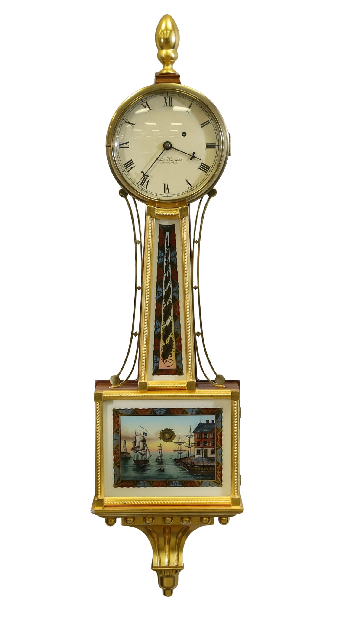 Foster S. Campos Massachusettes Banjo Clock: Mahogany and giltwood case with acorn finial, reverse painted throat and pendulum window tablet of a harbour scene, signed by on inside glass "Moberg", fluted bracket and drop finial. Eight-day
