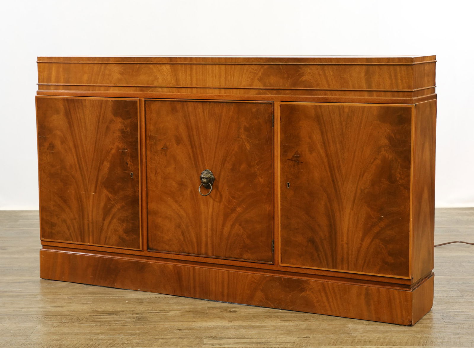Figured Mahogany Veneer Console Cabinet: Lighted frosted glass top over three doors on a plinth base. Wear and repairs to the veneer around the bottom edge. 31"h x 52"w x 9.5"d