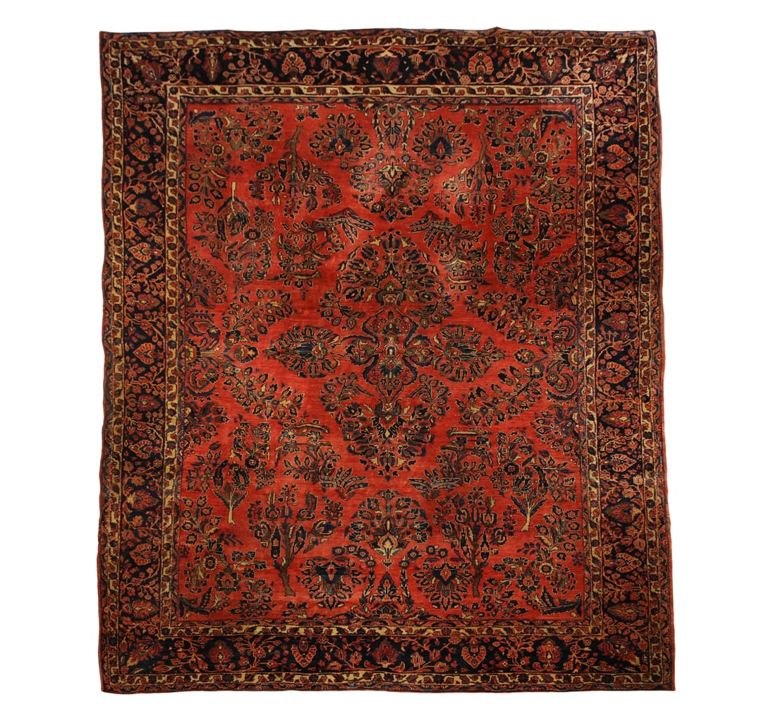 Persian Sarouk Carpet: Hand knotted wool with an all over palmette and foliate motif field with an alternating floral cartouche and vine main main border. Polychrome colors of red, navy blue, brown, and cream. Early 20th