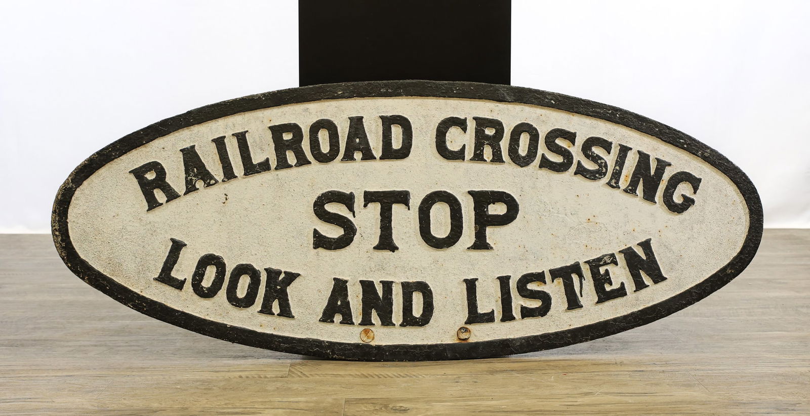 Cast Iron Railroad Crossing Sign: Oval black and white painted "Railroad Crossing, Stop, Look, And Listen" sign, cast marked "M-24195". 19"h x 48"w