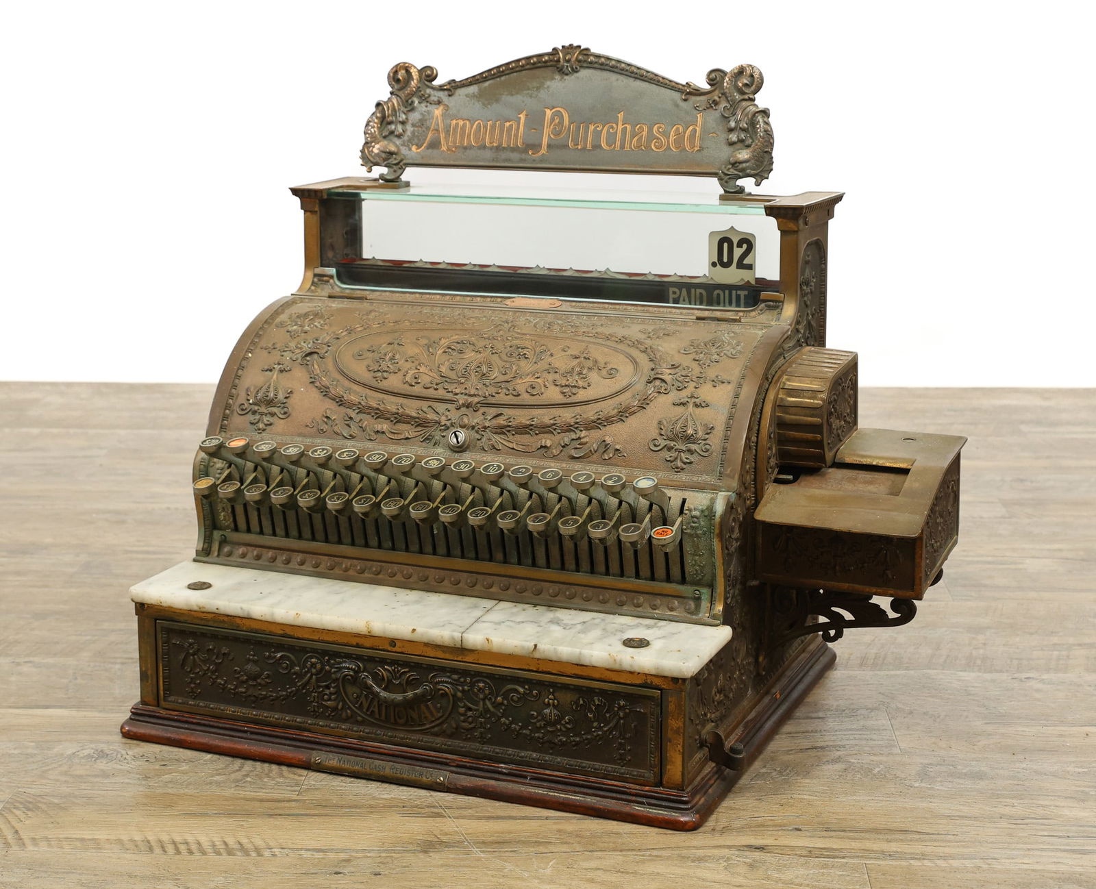 National 356-G Cash Register: Ornate repousse brass case with a dolphin motif top plate and side receipt printer on an oak molded plinth base. Serial No. 903951. 22"h x 25"w x 17"d