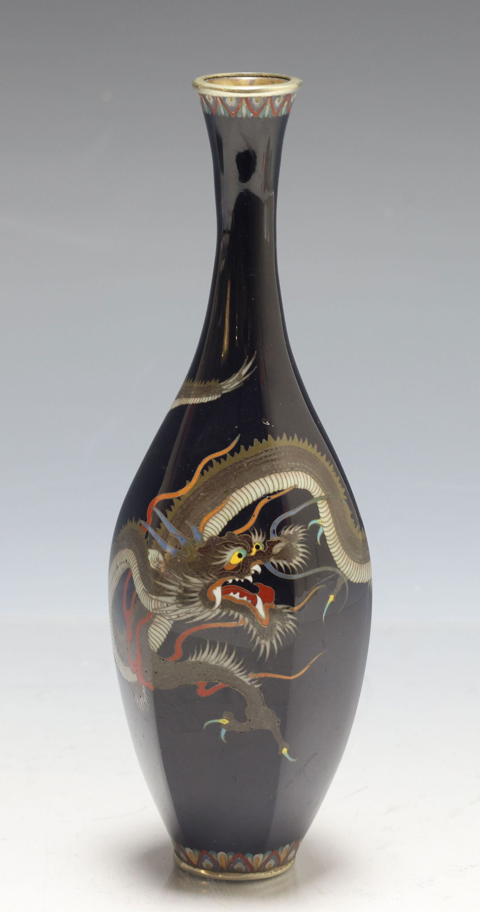 Tamura Japanese Cloisonne Vase: Meiji - Taisho era hexagonal silver wire cloisonne bottle vase decorated with a dragon in flight on a black ground. Marked to the foot. 6"h x 2"w