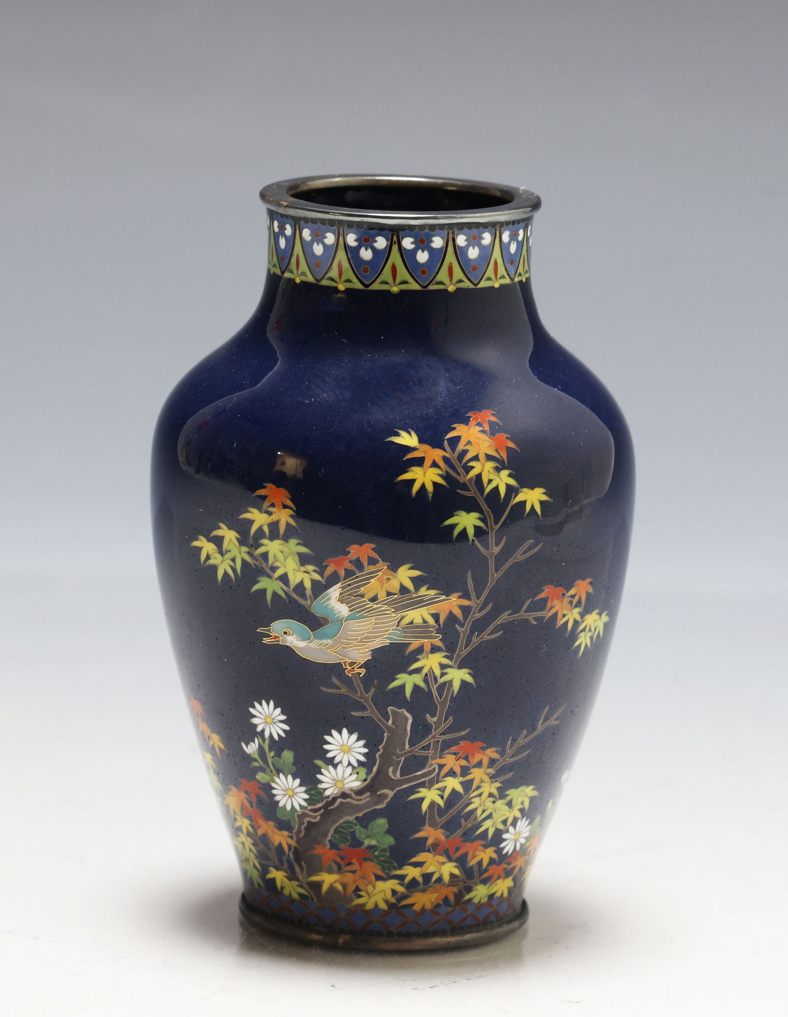 Hayashi Kodenji Japanese Cloisonne Vase: Meiji era silver and gold wire cloisonne vase decorated with a bird among maple and other flowers, with stylized rosette, lappet, and fish roe borders, on a midnight blue ground. Marked to the foot. 3