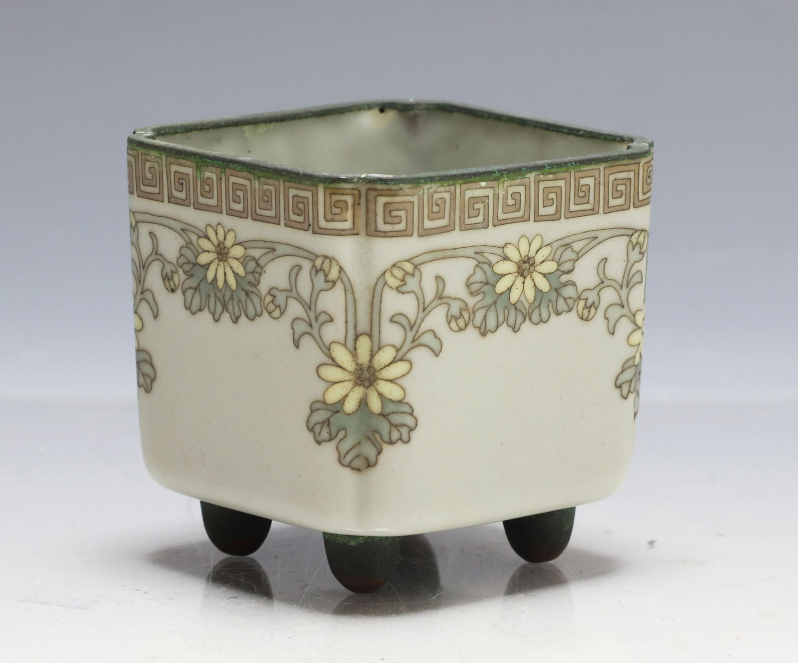 Japanese Cloisonne Planter: Meiji - Taisho era silver wire cloisonne square flower planter with concave corners, decorated with floral gadroons and a meander border on a celadon ground, and raised on ball feet. Unmarked. 2.25"h