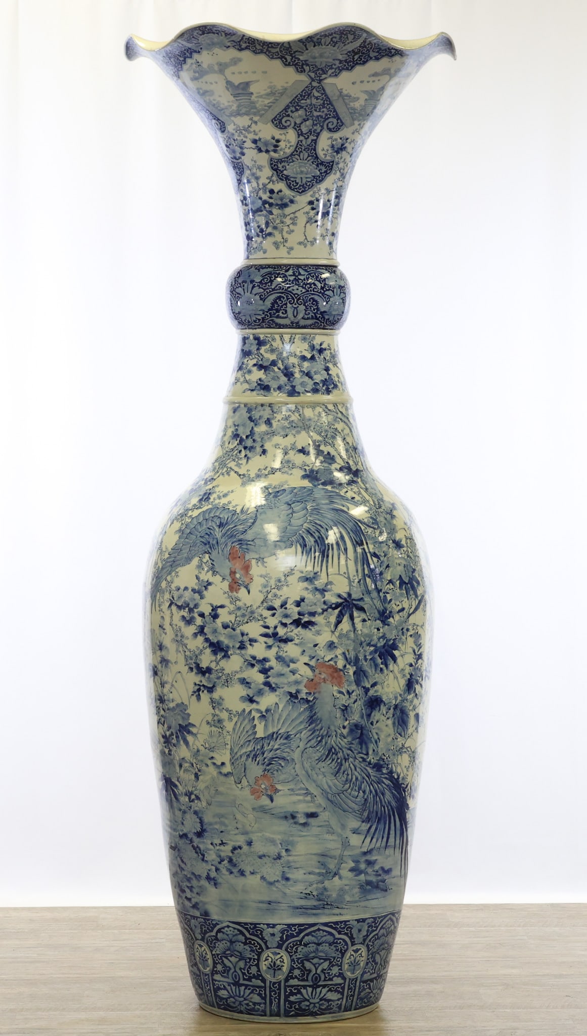 Japanese Imari Porcelain Palace Vase: Meiji - Taisho era blue, white, and copper red two-part porcelain palace vase, the lower part in the form of a garlic mouth vase, decorated with roosters surrounded by flowers in a garden setting abov