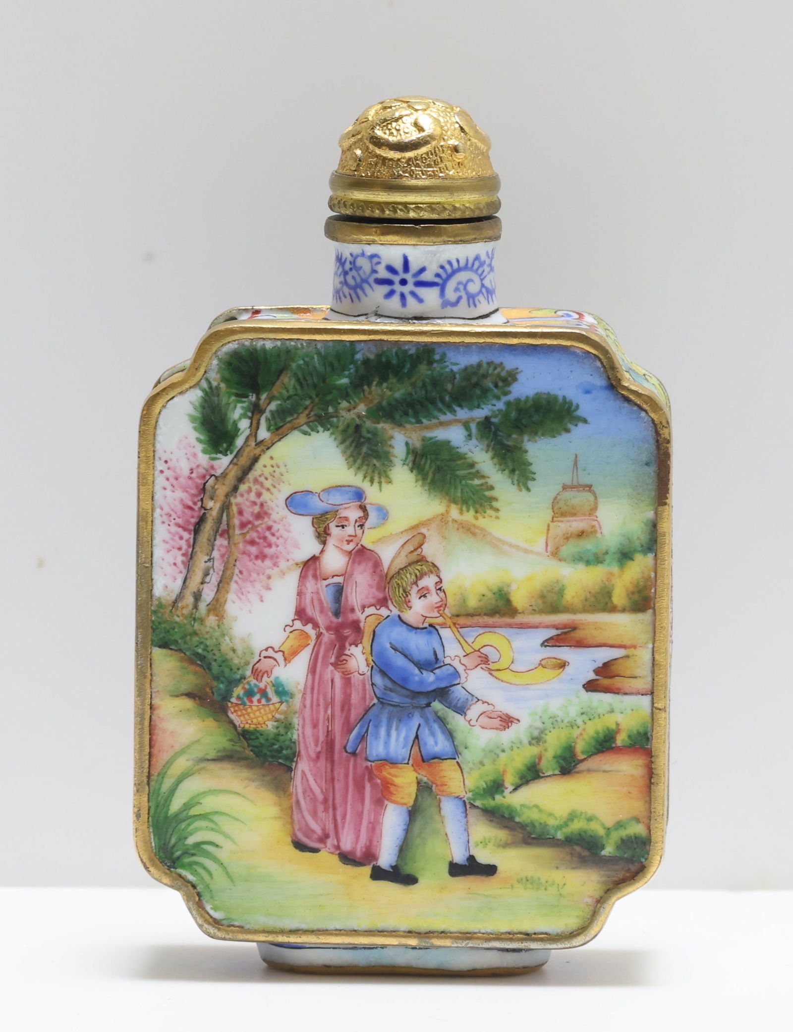 Chinese Snuff Bottle: Painted enamel snuff bottle with each side decorated with European genre scenes in a pastoral landscape framed by gilt borders; the base with an oval blue-enameled panel bearing a Qianlong reign