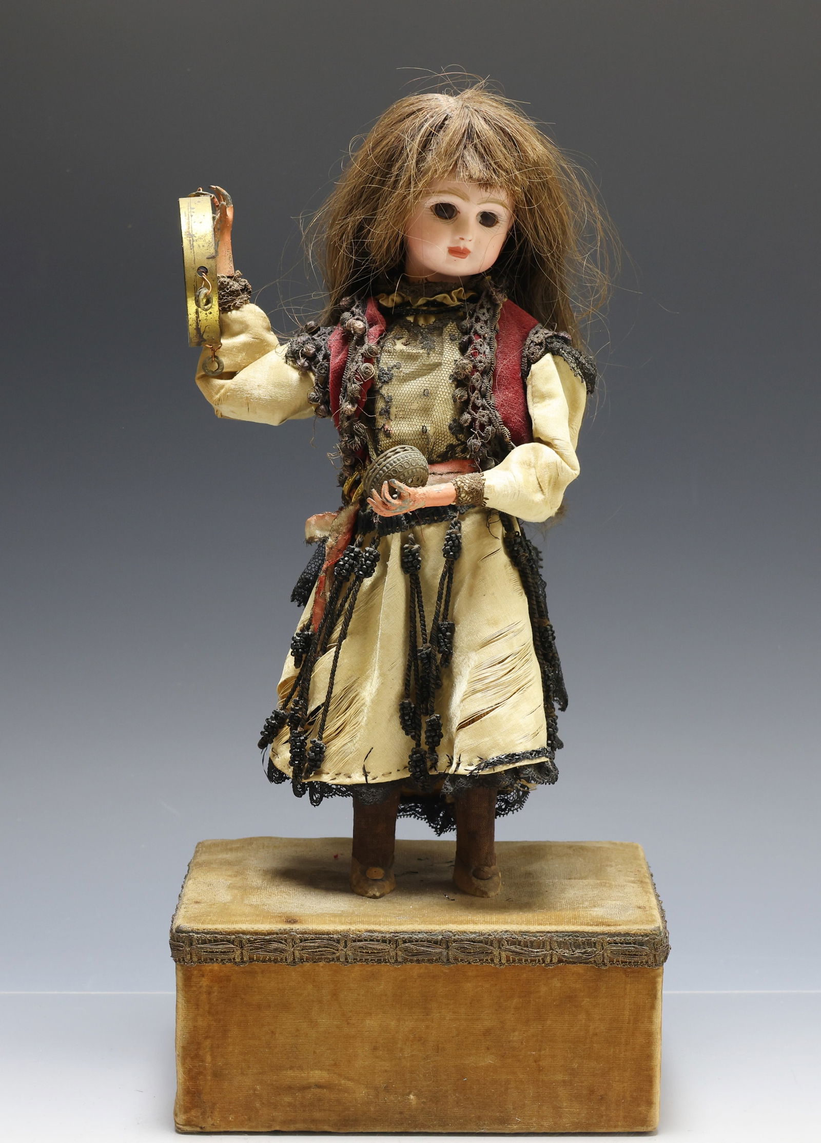 French Automaton Bisque Head Doll: French automaton doll with bisque head. Head and arms move when key wound, does not include a key. Human hair wig, glass eyes and dressed in layered silk costume. Discoloration and loss due to age. Do